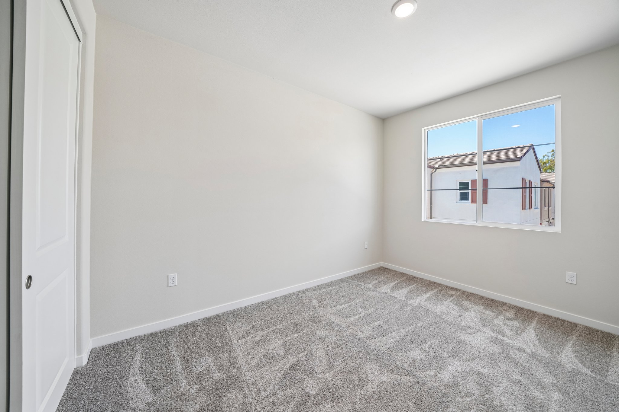 A room with a window and carpet.
