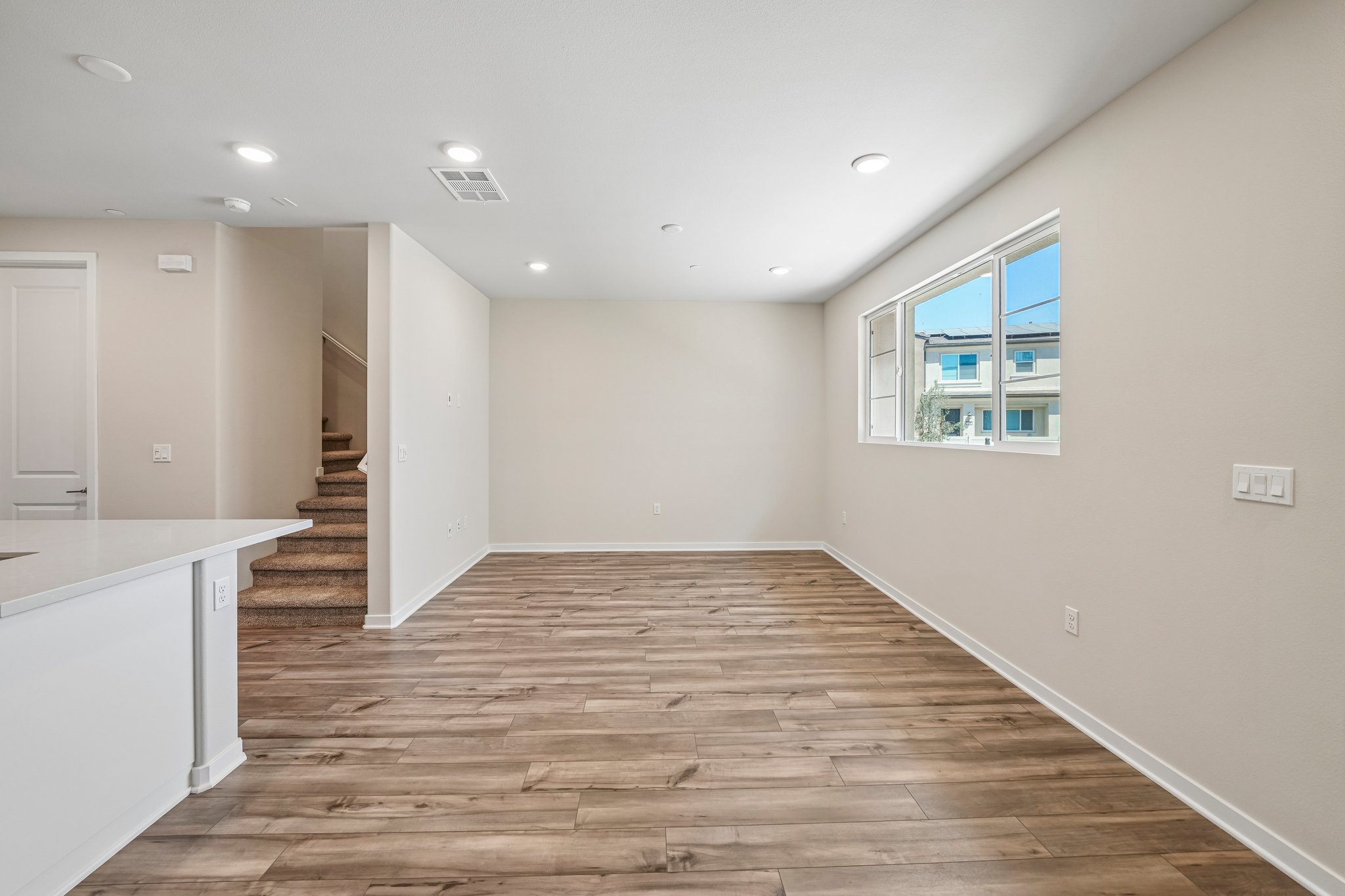 A large empty room with a wood floor and white walls.