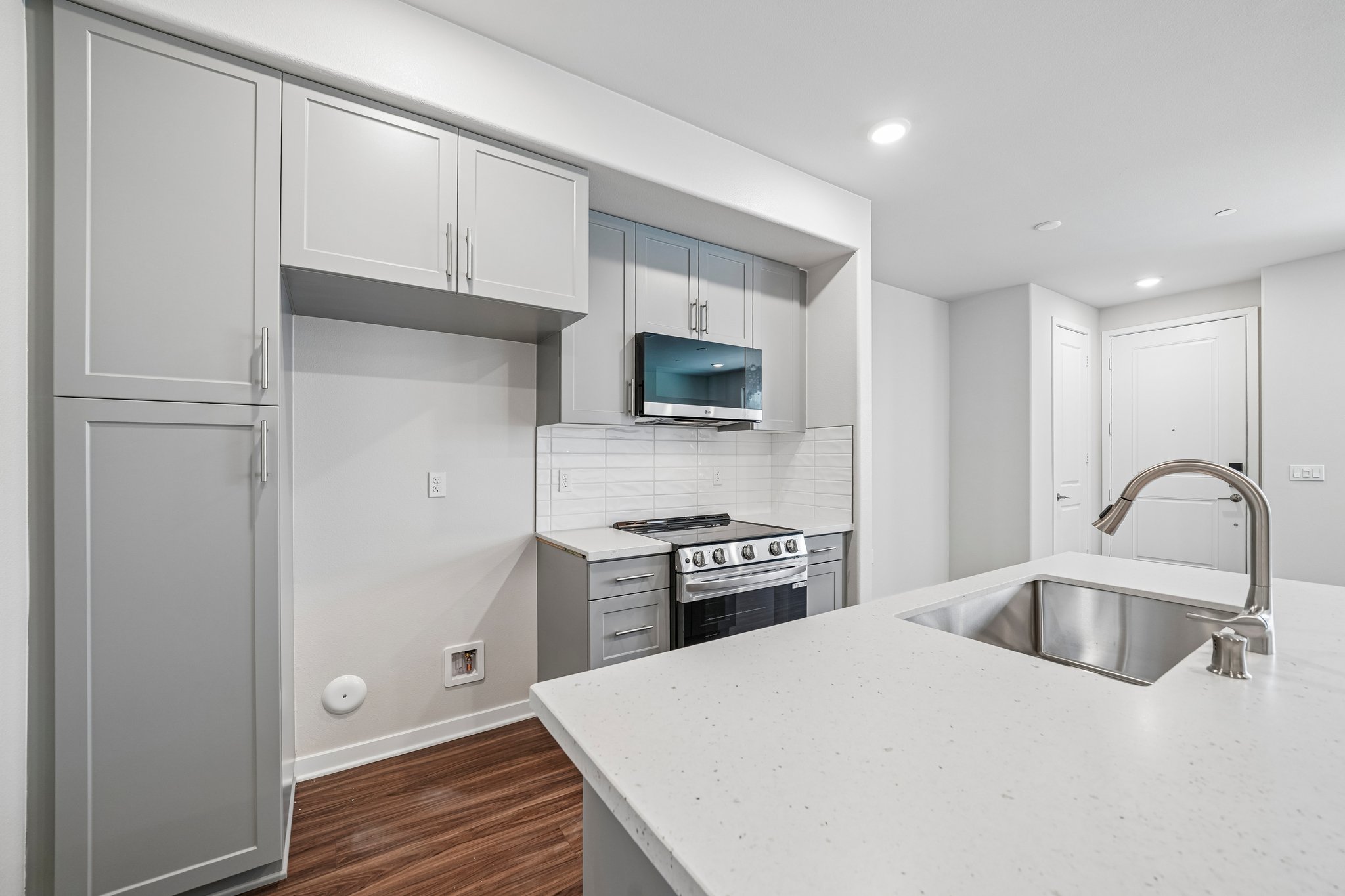 A kitchen with white cabinets.