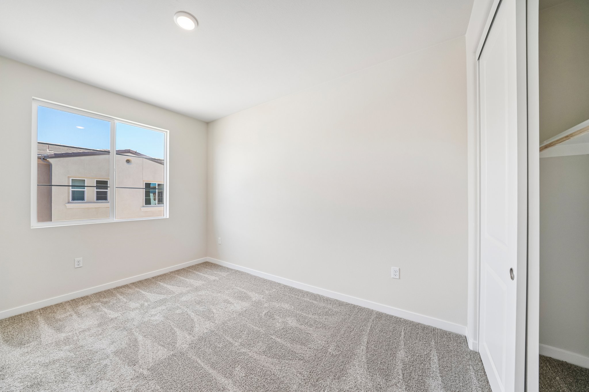 A room with a window and a carpet.