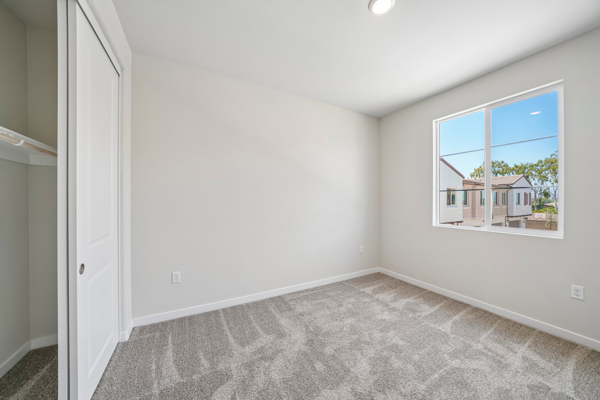 A room with a window and carpet.