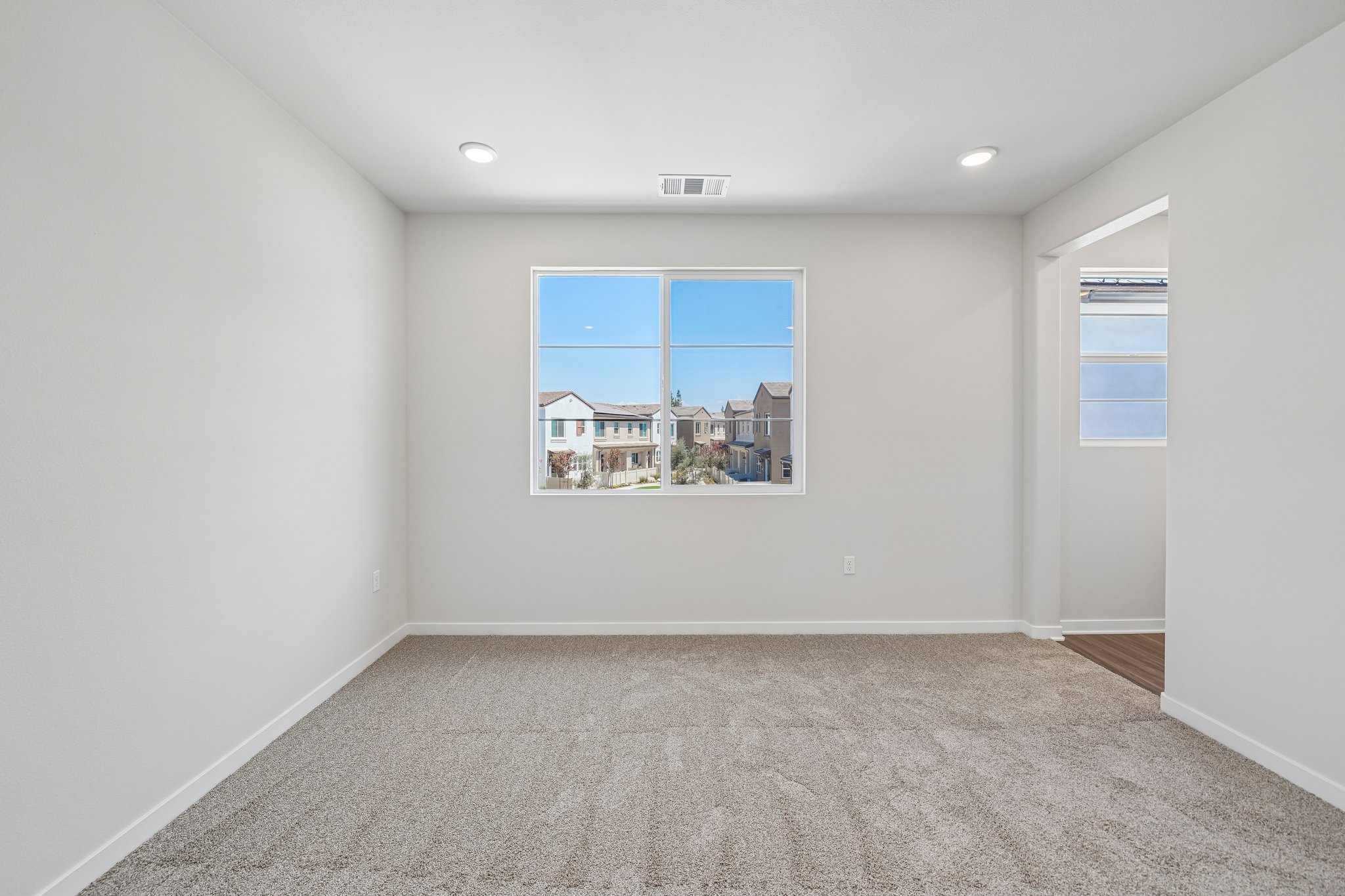 A room with a window and a carpet.