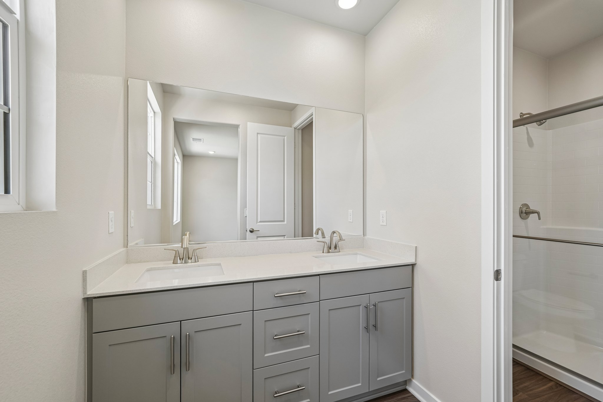 A bathroom with a sink and a shower unit.