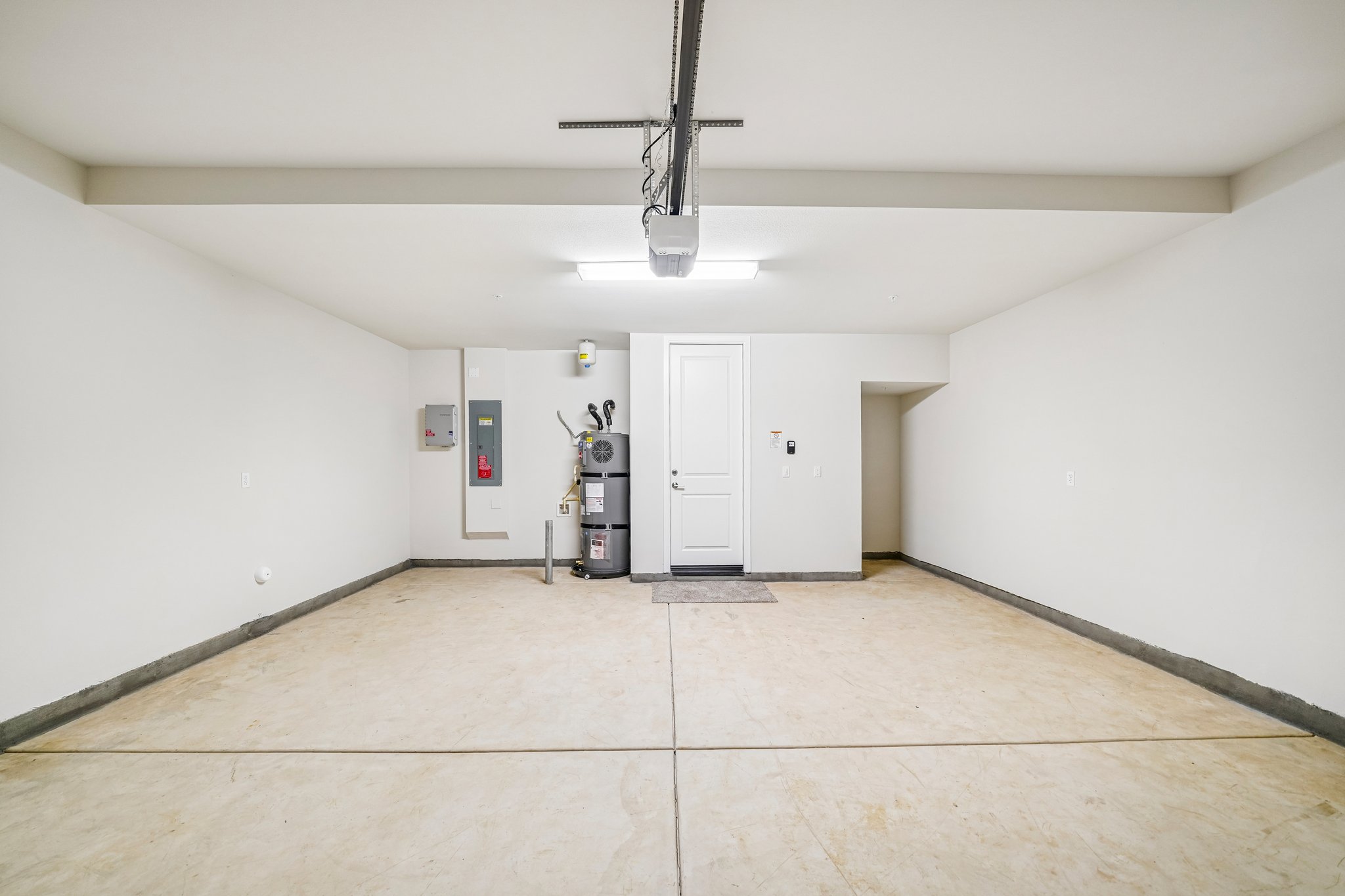 A room with white walls and a white floor with a light fixture.