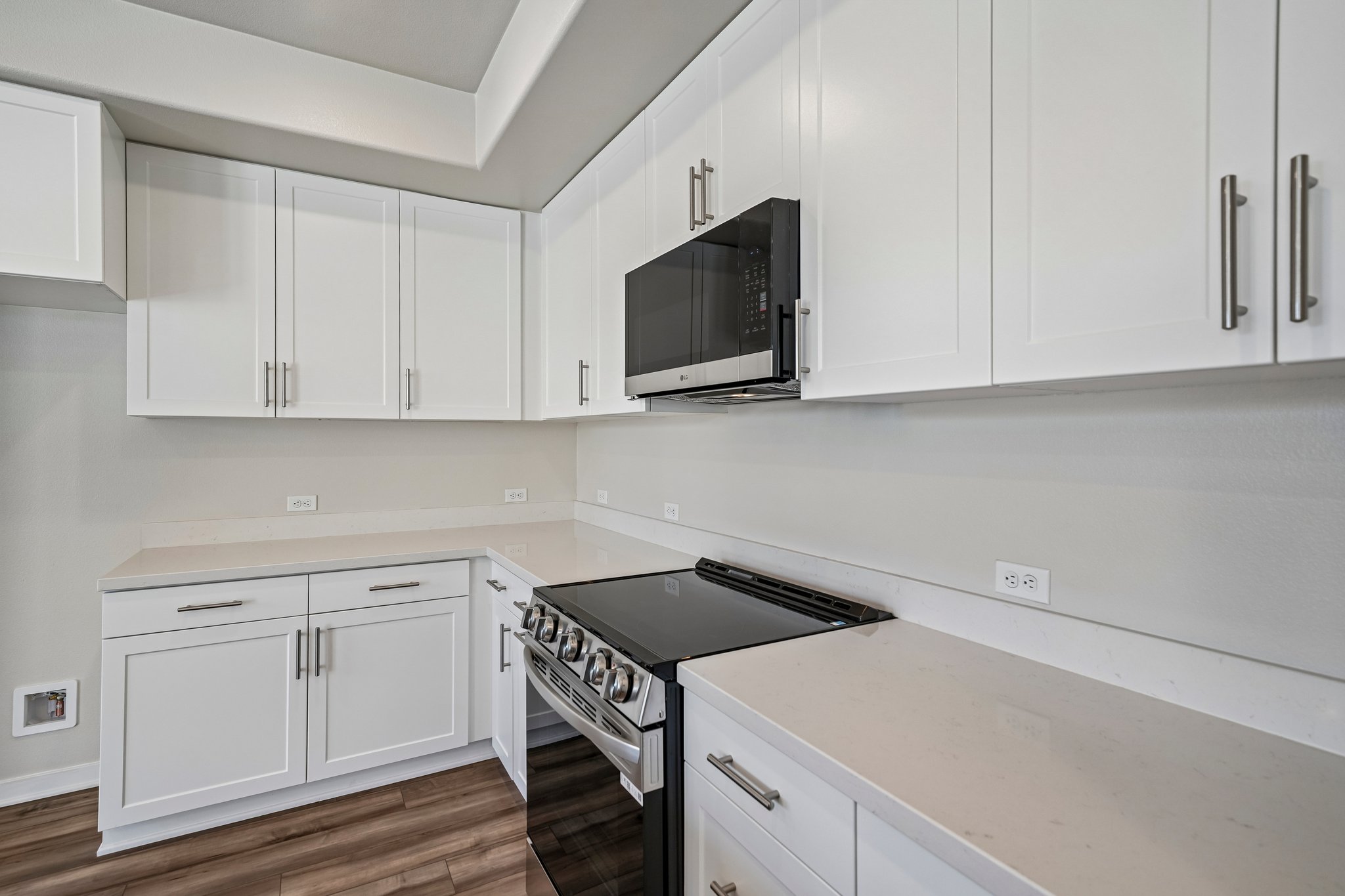 A kitchen with white cabinets.