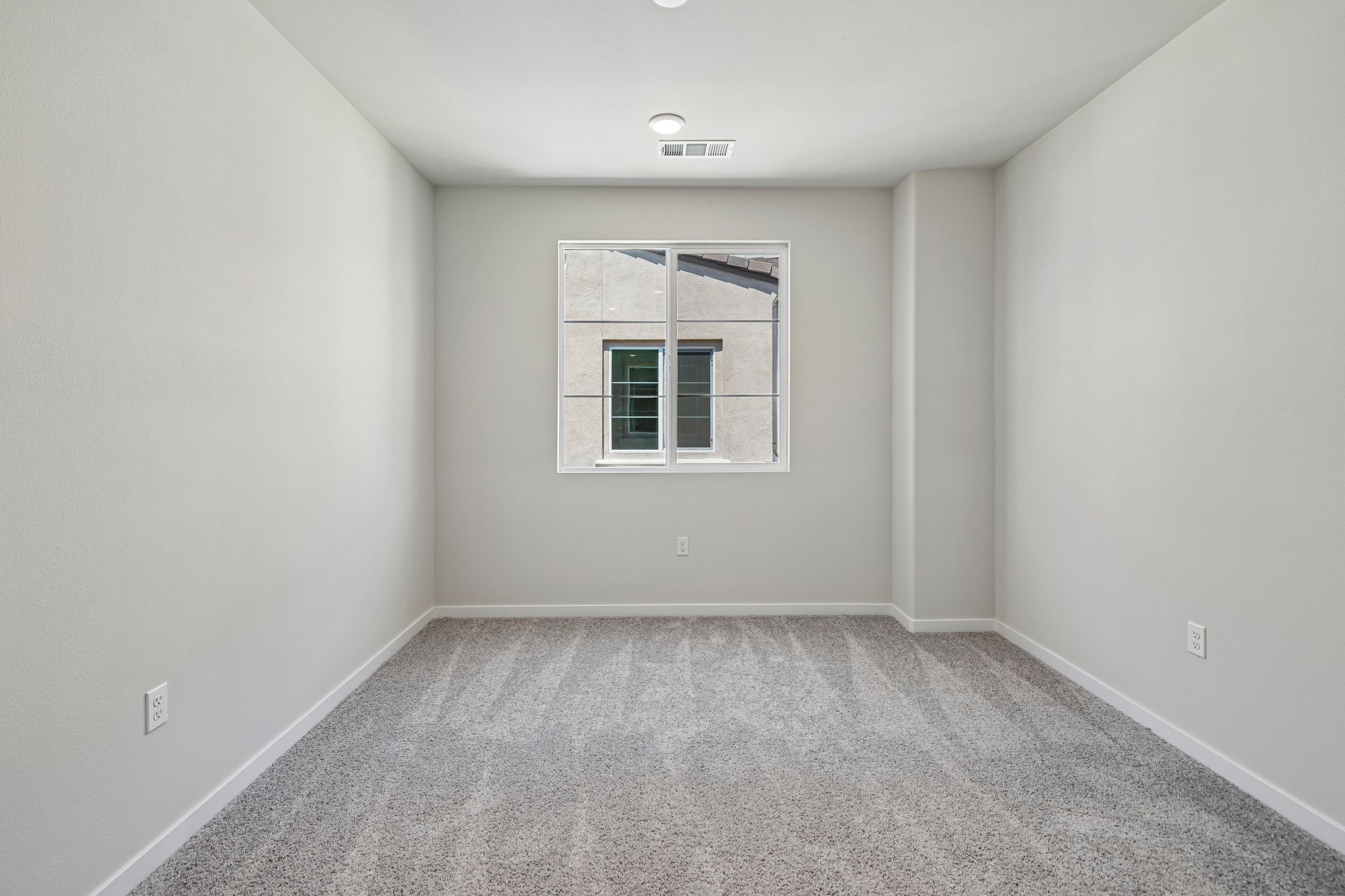 A room with a window and carpet.