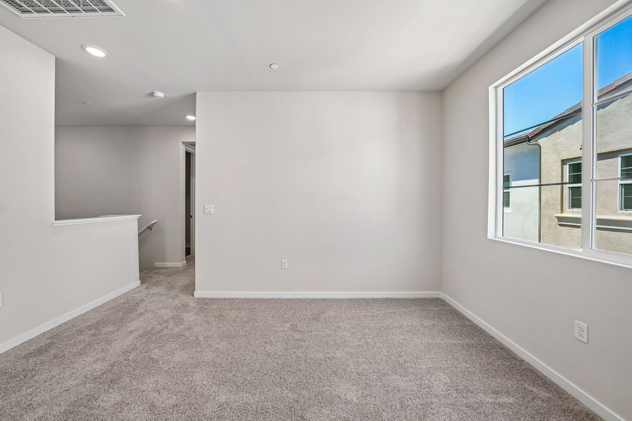 A room with a white wall and a window.