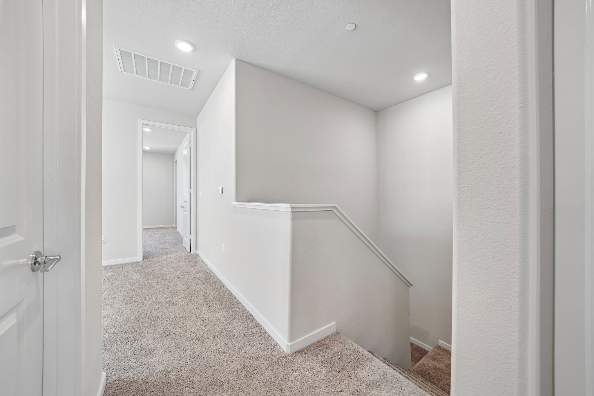A white hallway with a white wall.