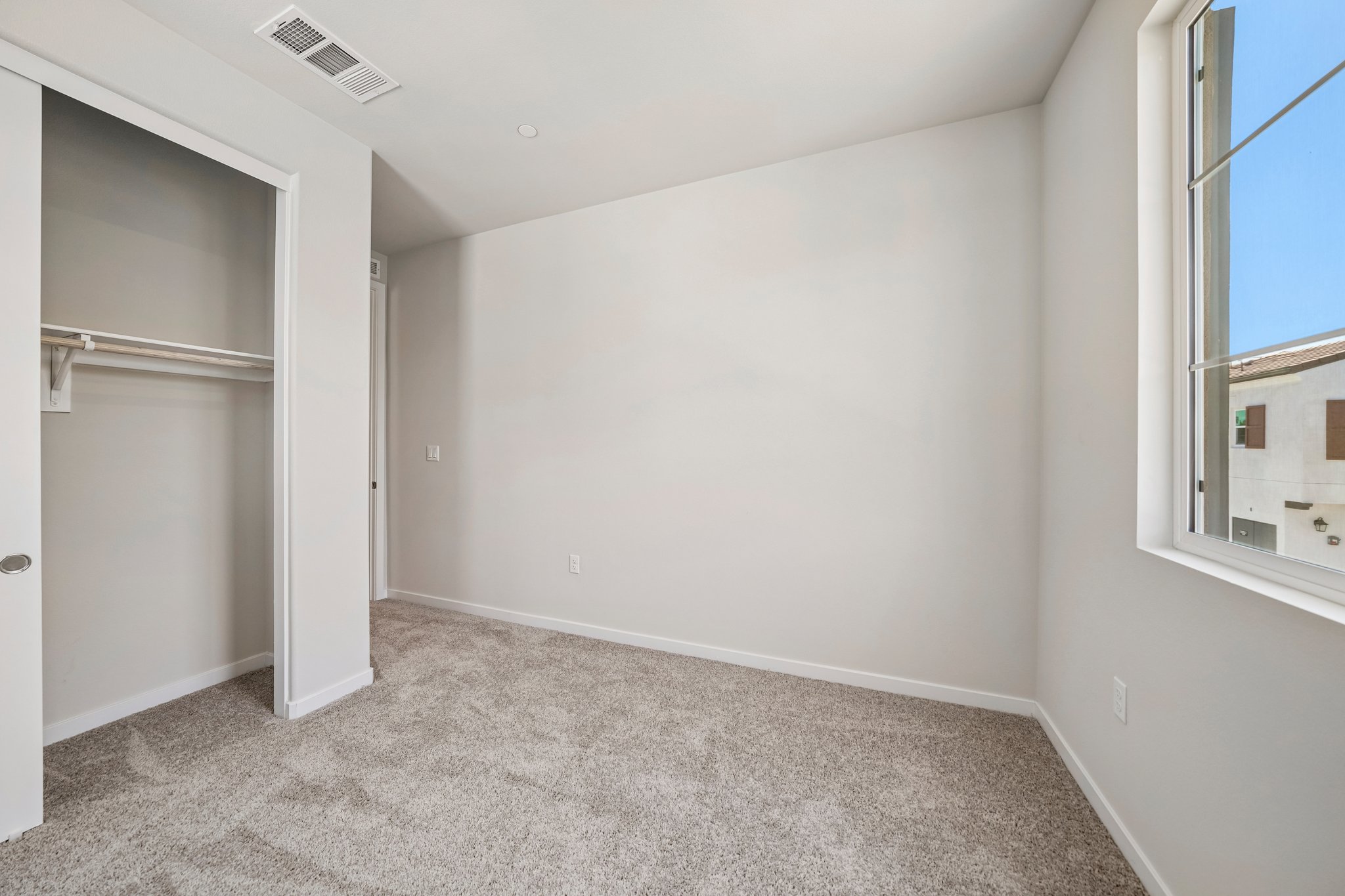A room with a carpet and a window.