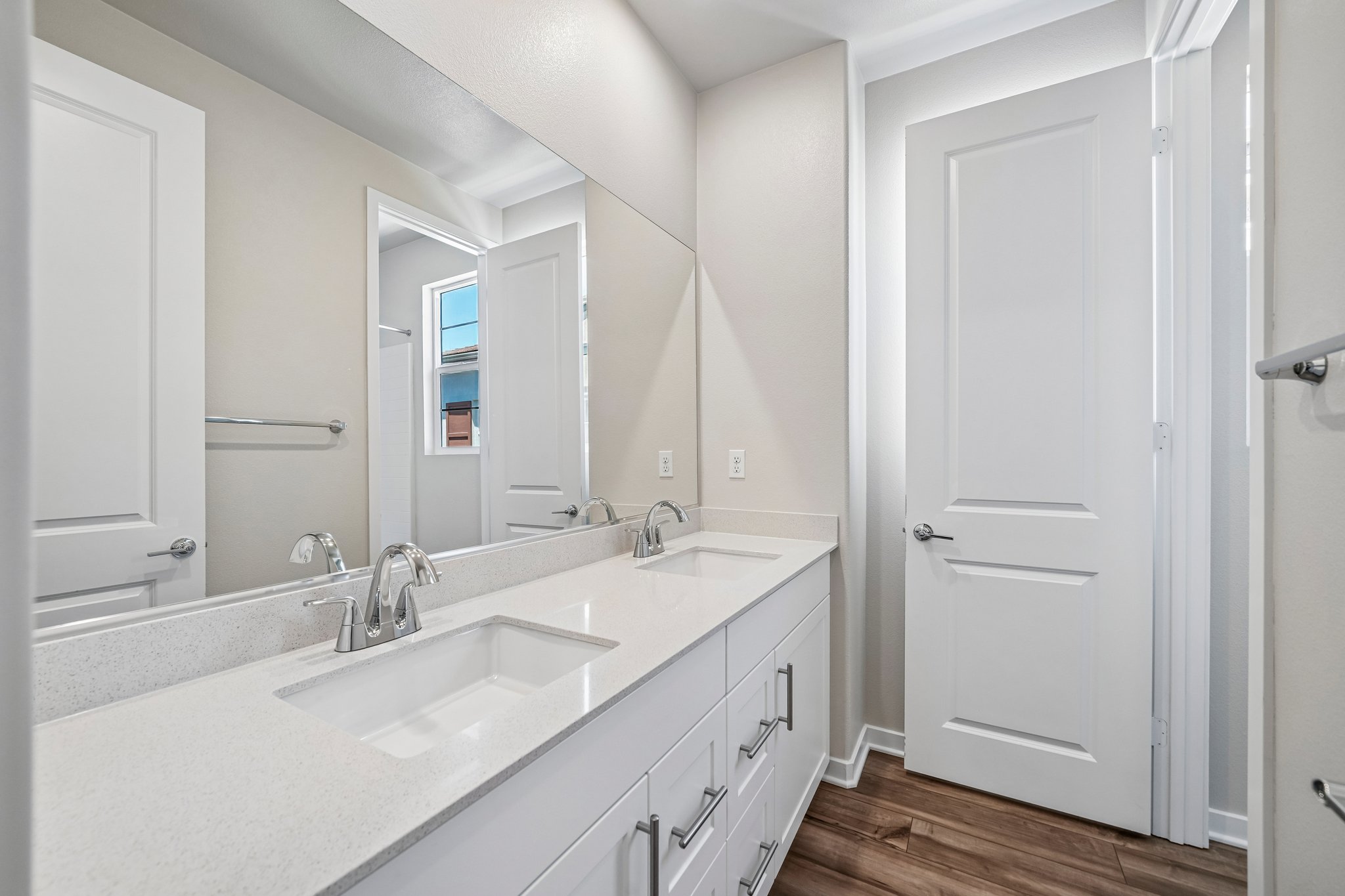 A bathroom with a large mirror.