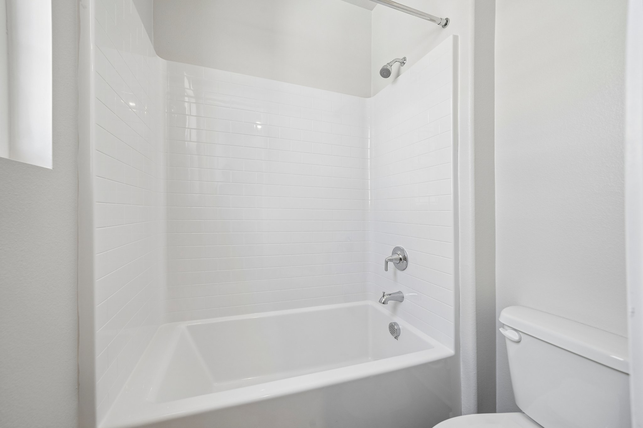 A bathroom with a bathtub and toilet.