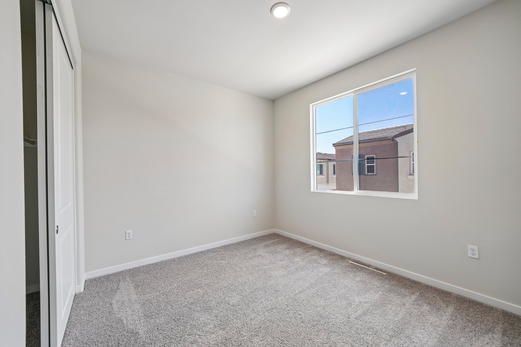 A room with a window and a carpet.