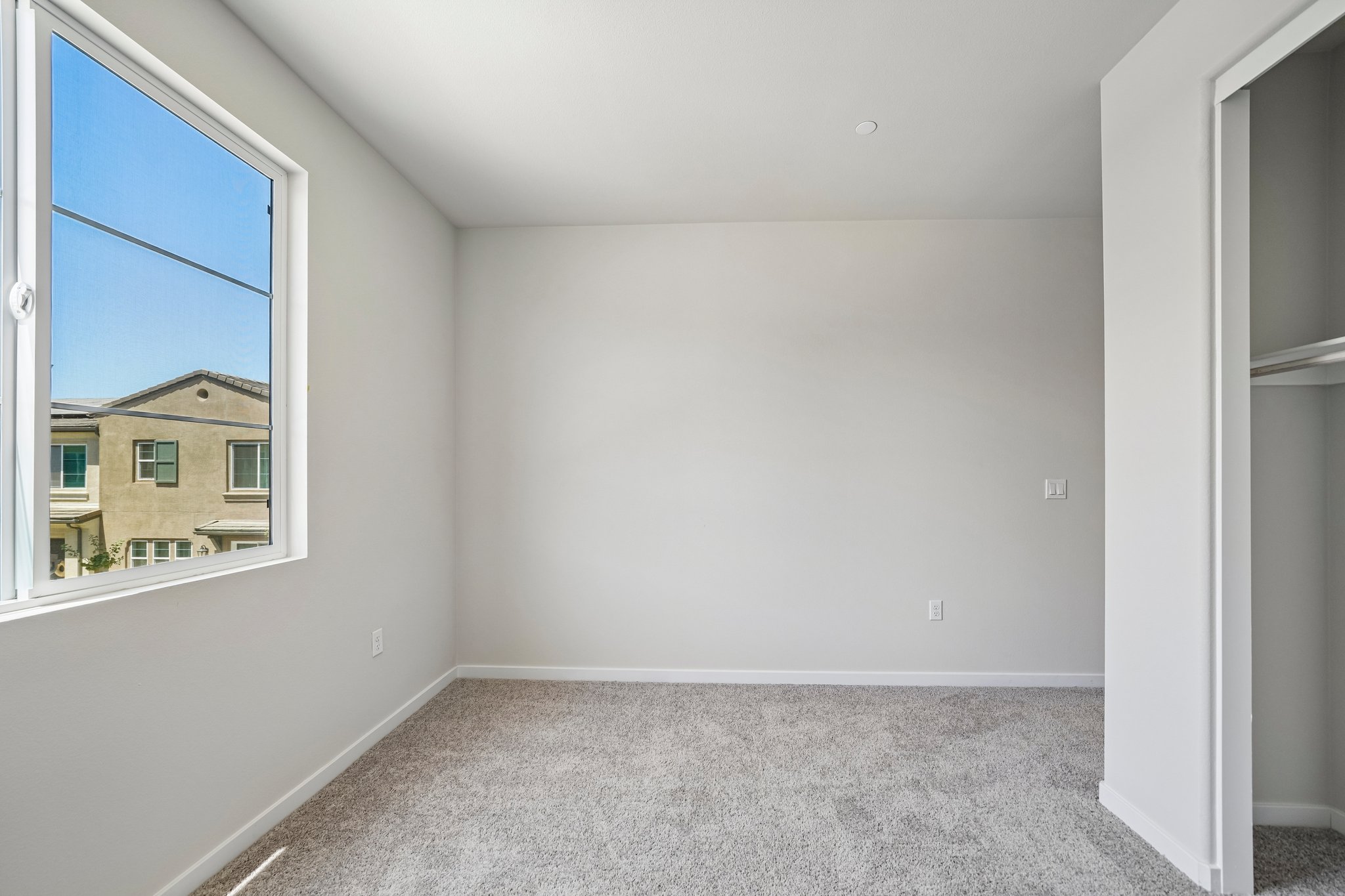 A room with a window and a carpet.