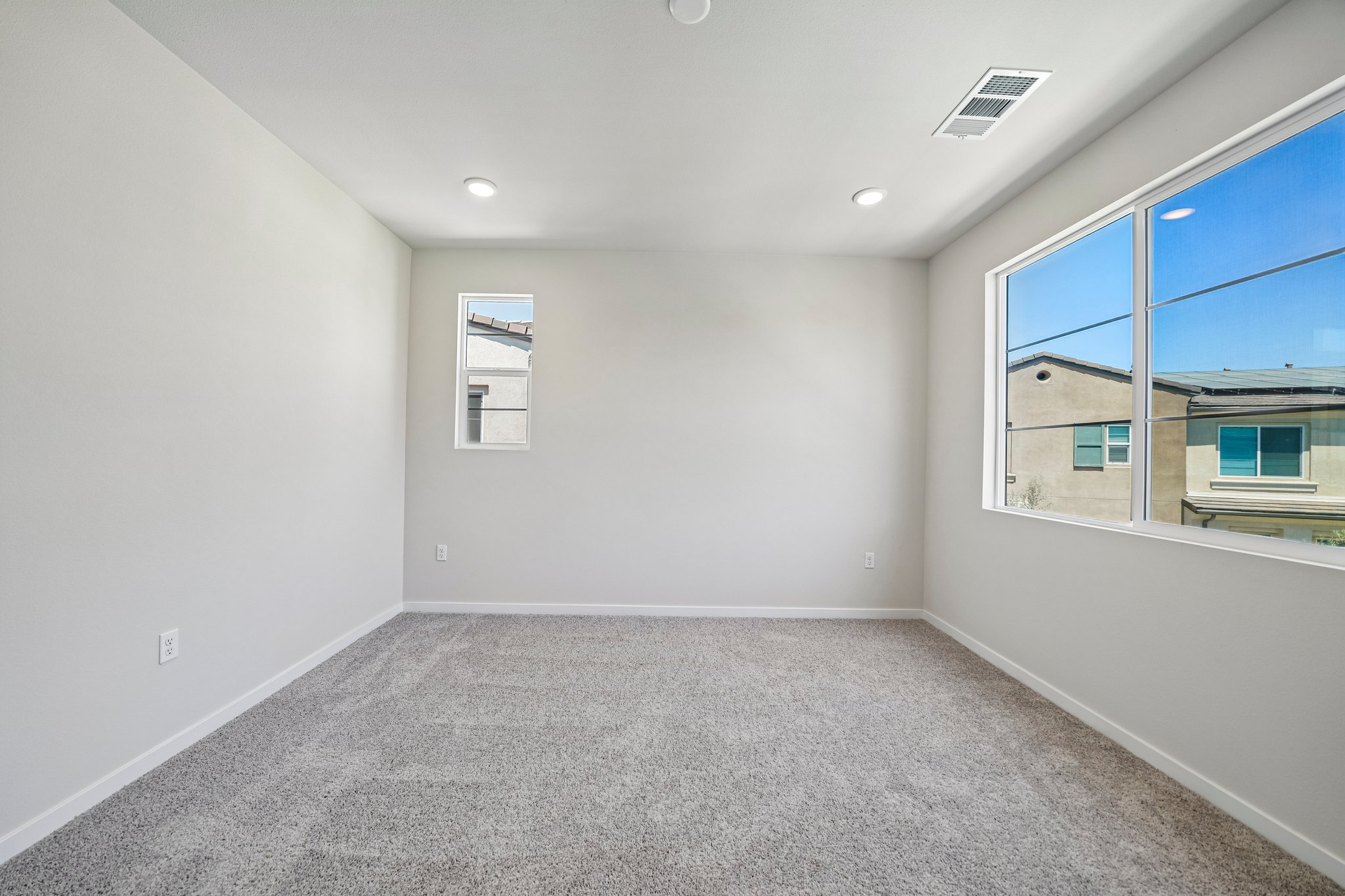 A room with a window and a carpet.