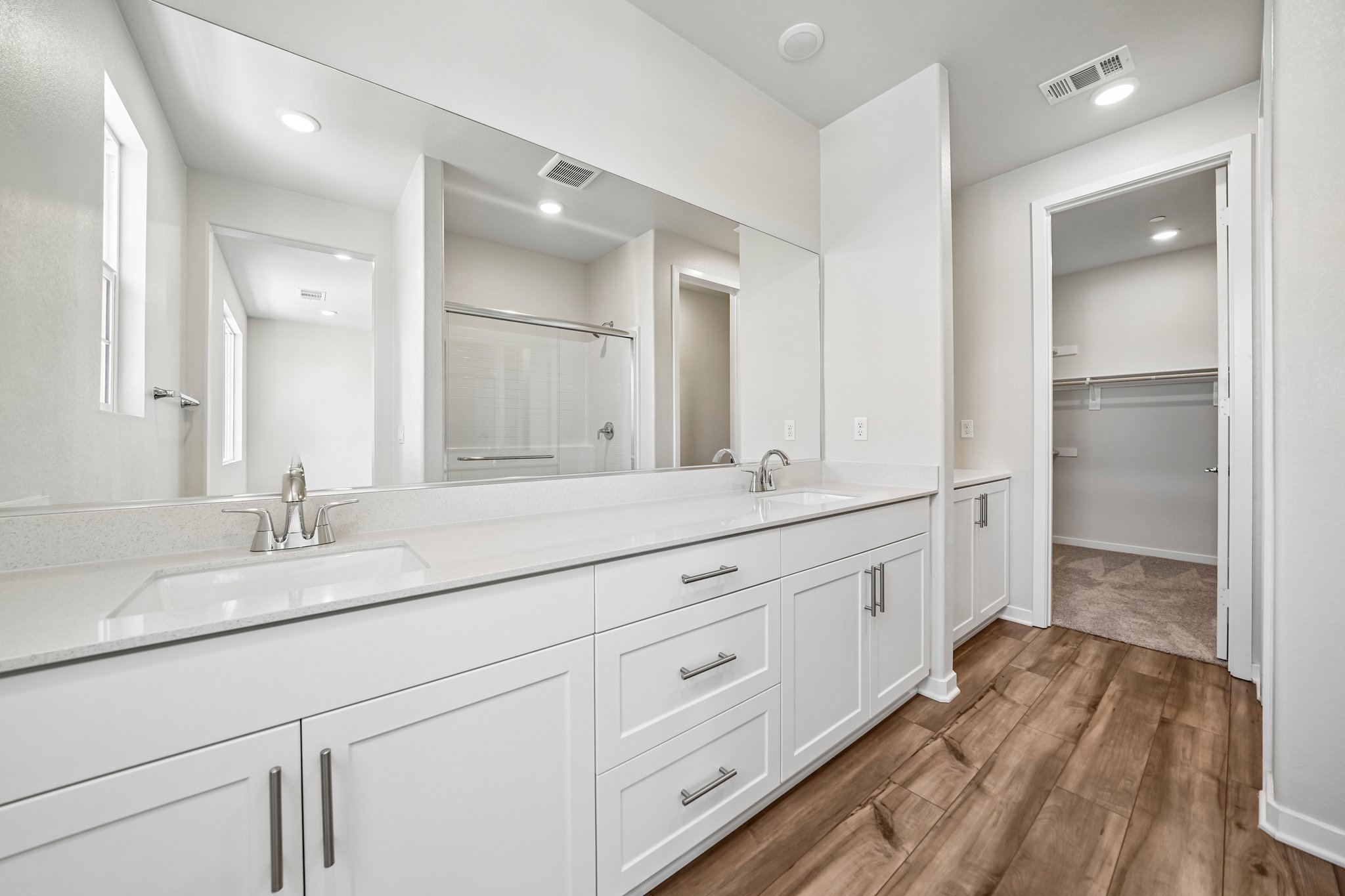A bathroom with white cabinets.