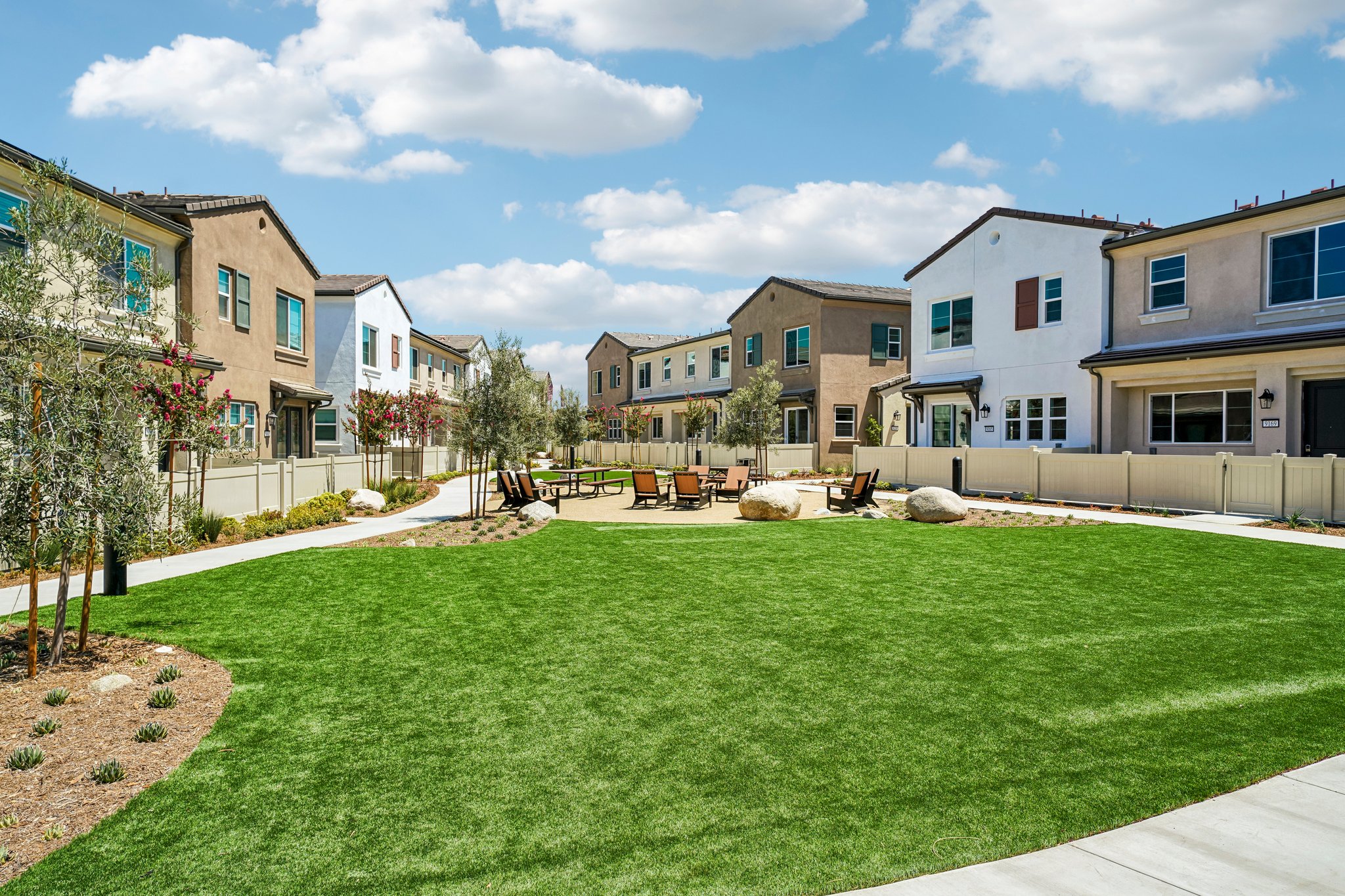 A large green lawn in front of a row of houses.