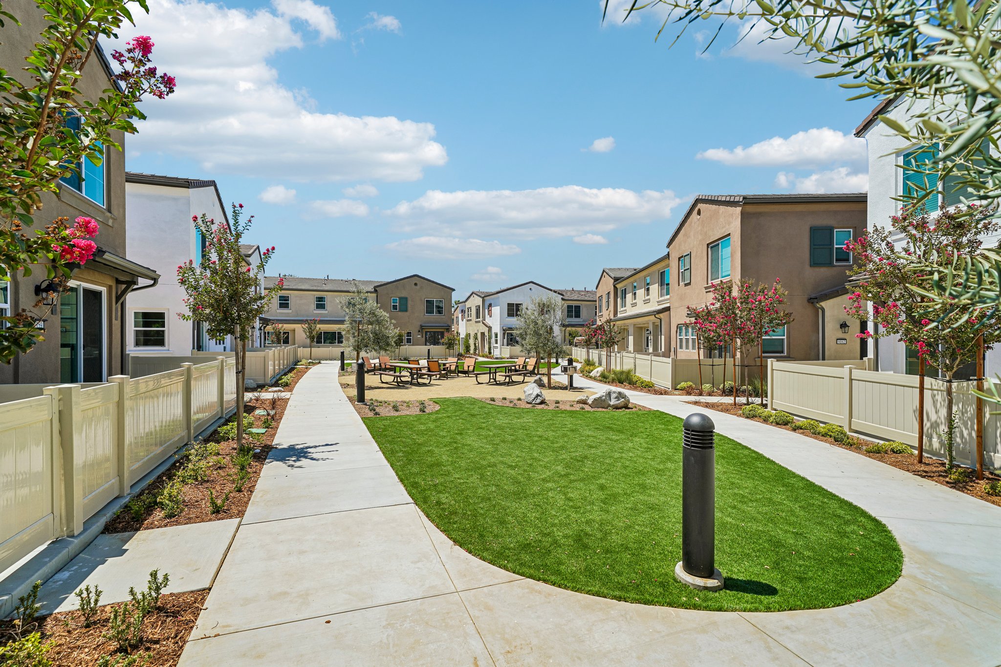 A sidewalk with grass and trees.