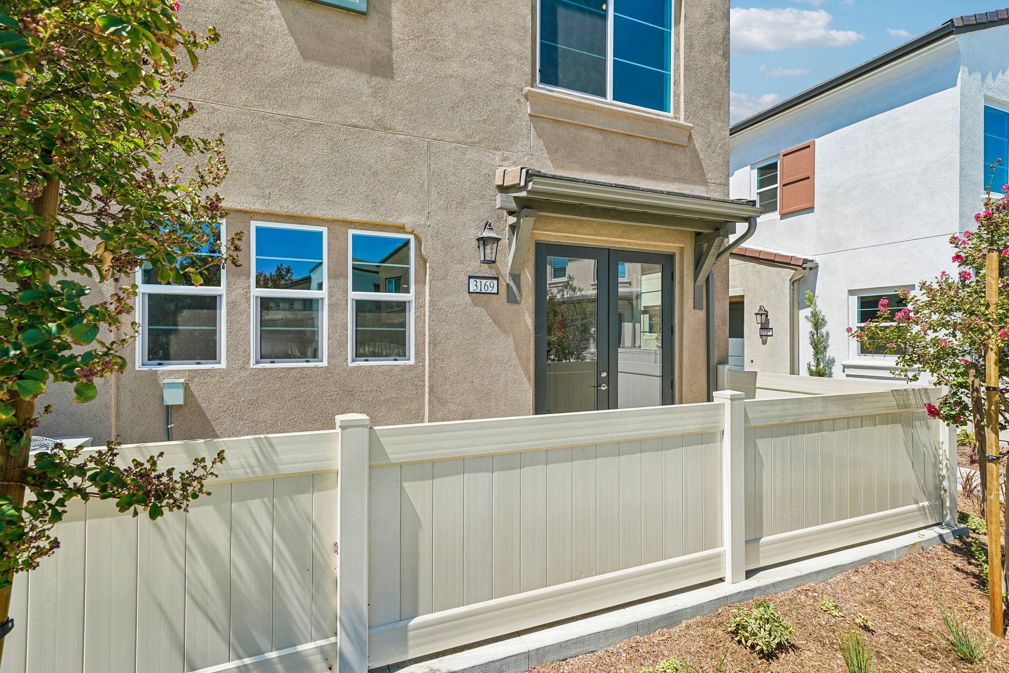 A white fence in front of a building.
