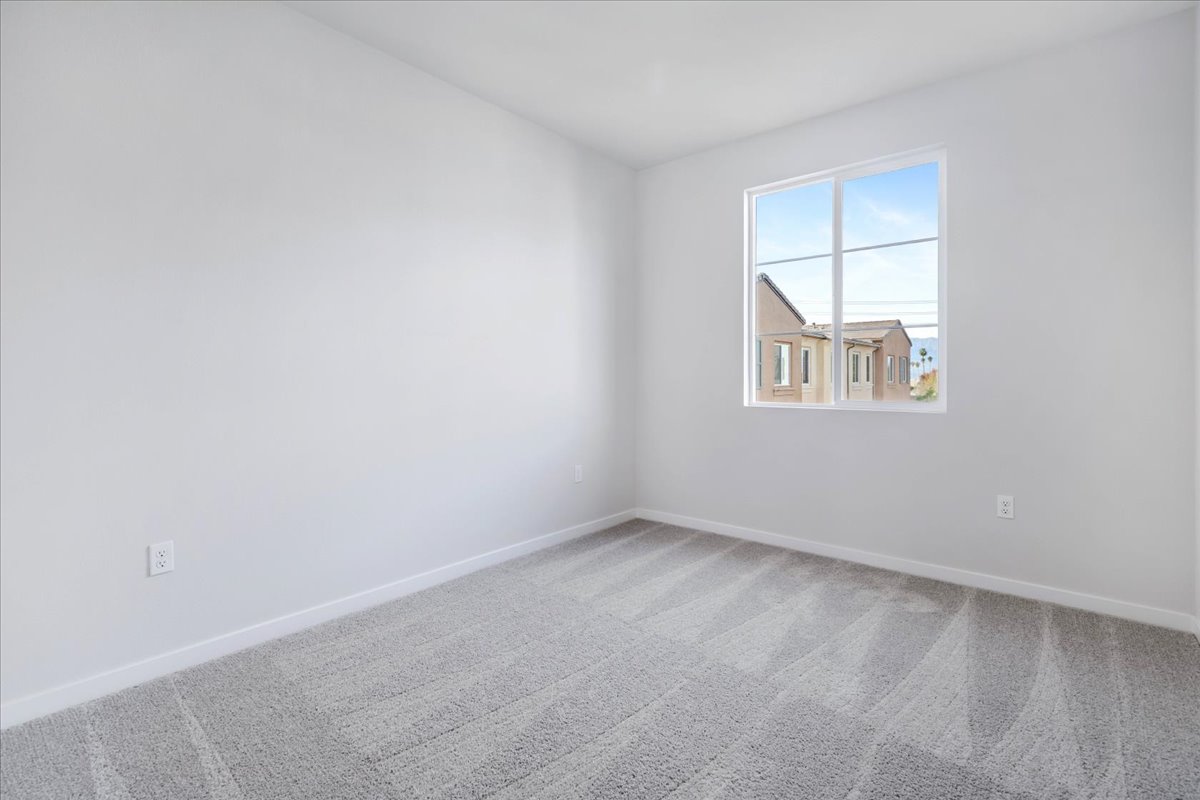 A room with a window and a white wall.