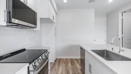 A kitchen with white cabinets.