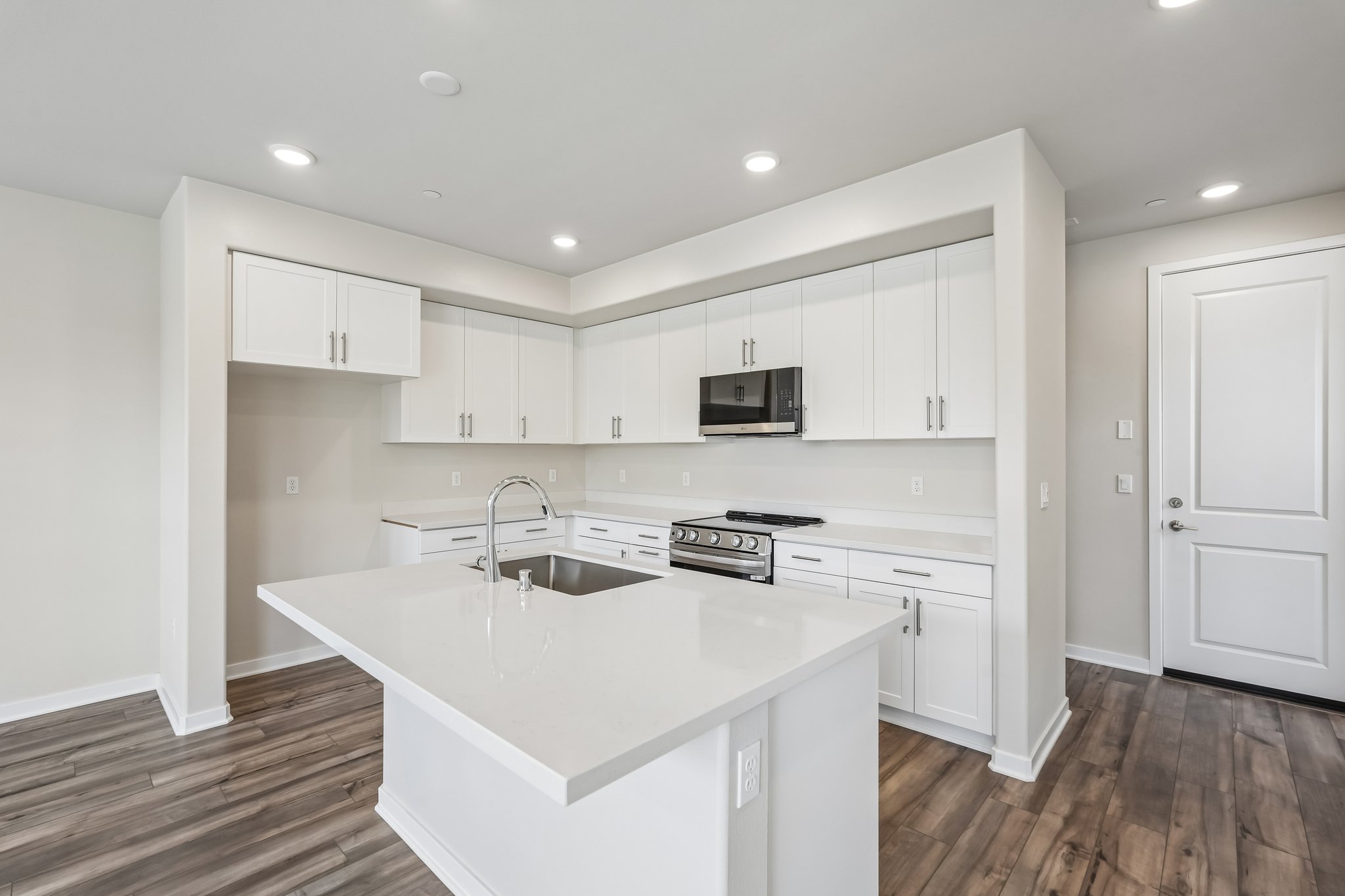 A kitchen with white cabinets.