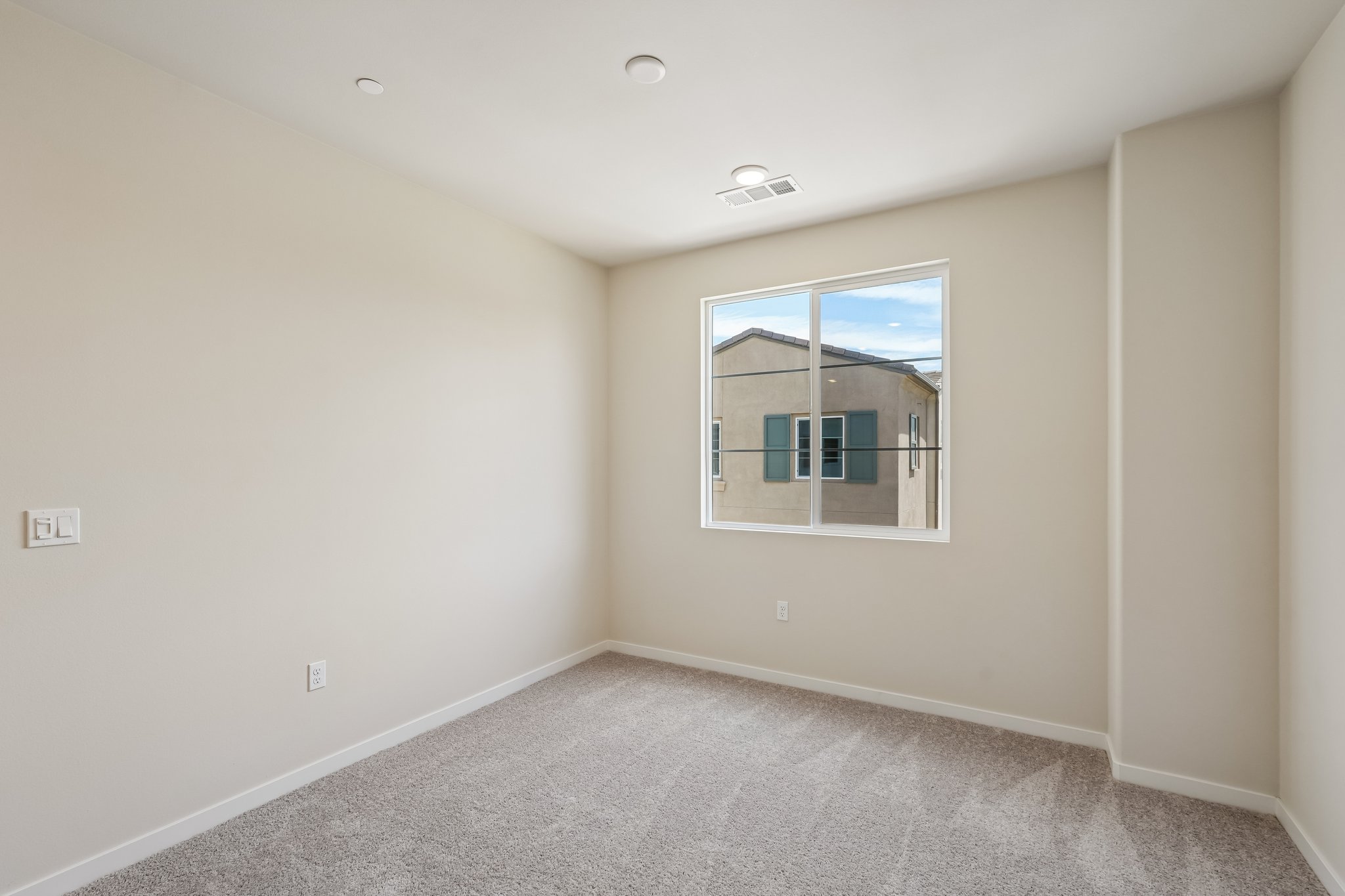 A room with a window and a carpet.