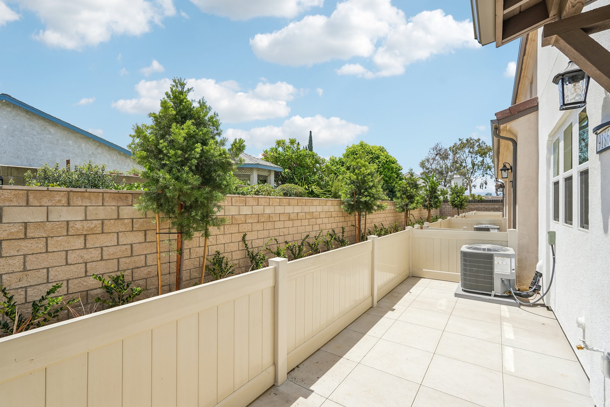 A white fence and a brick wall.