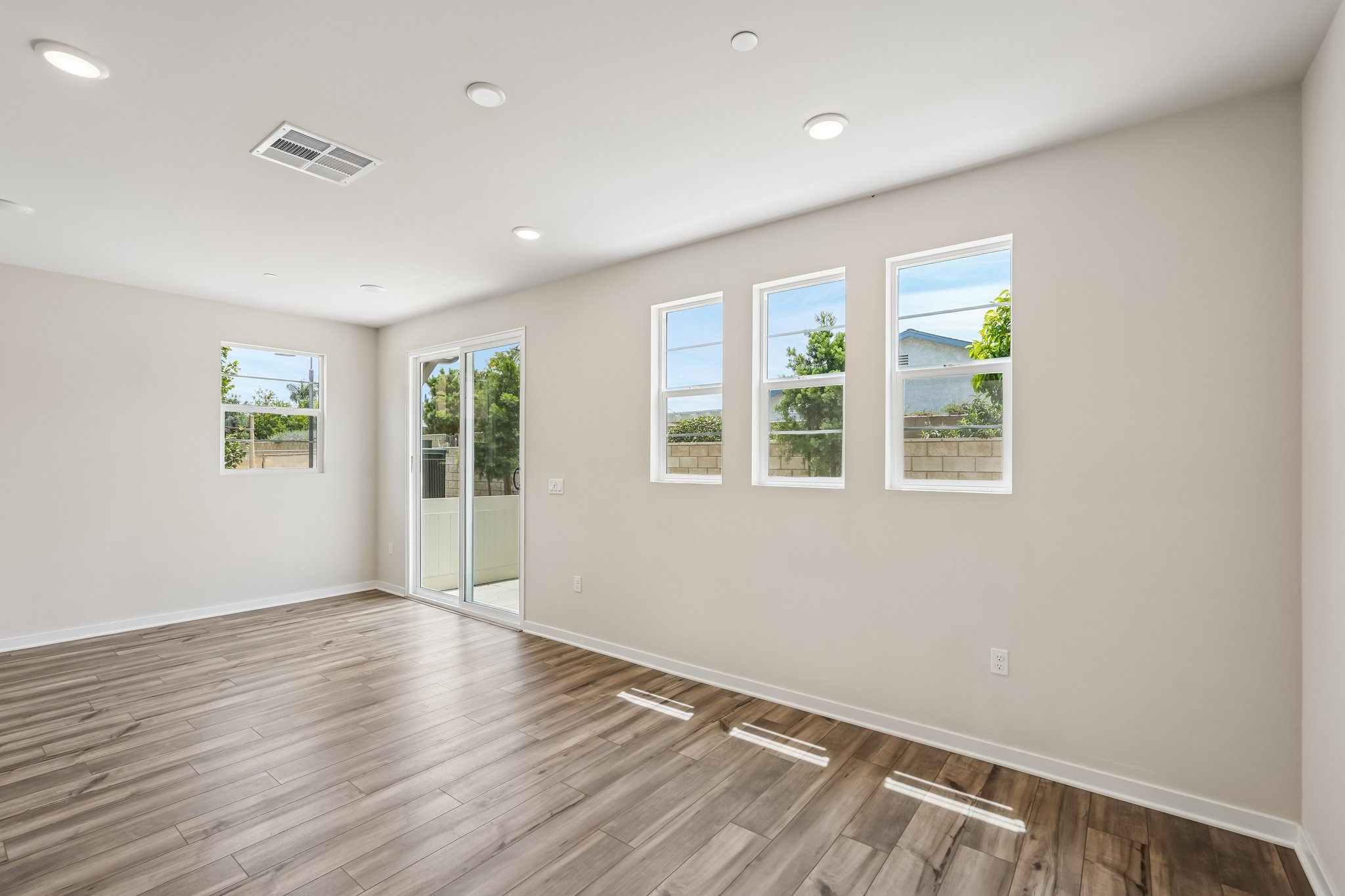 A room with windows and wood floors.