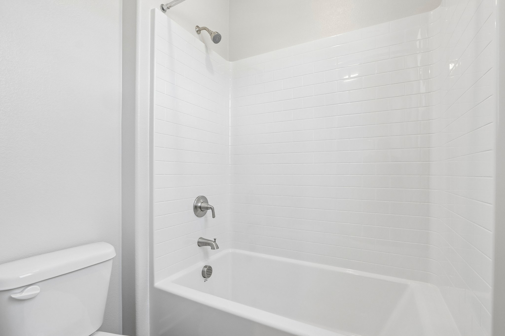 A bathroom with a bathtub and toilet.