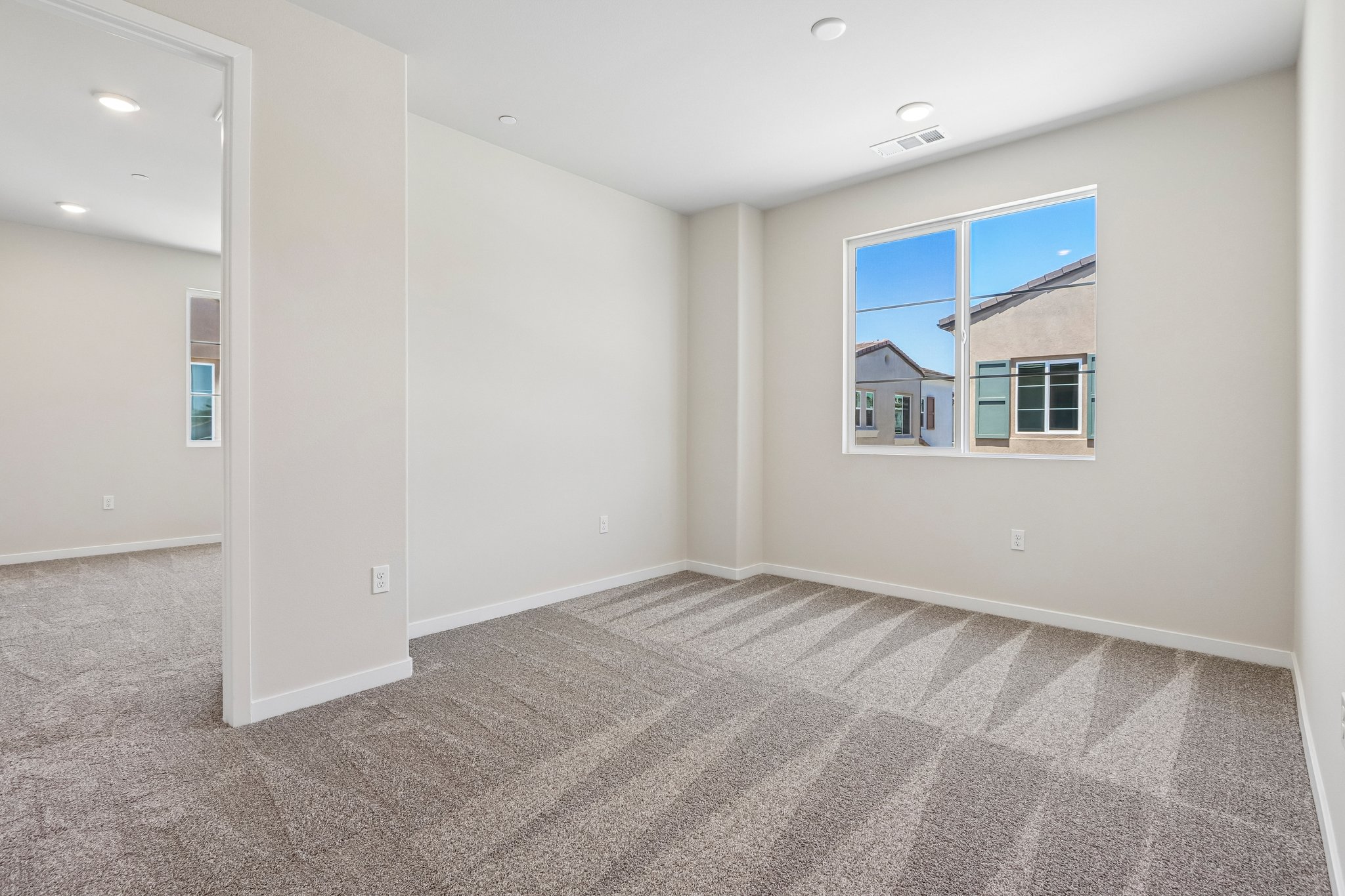 A room with a window and a carpet.