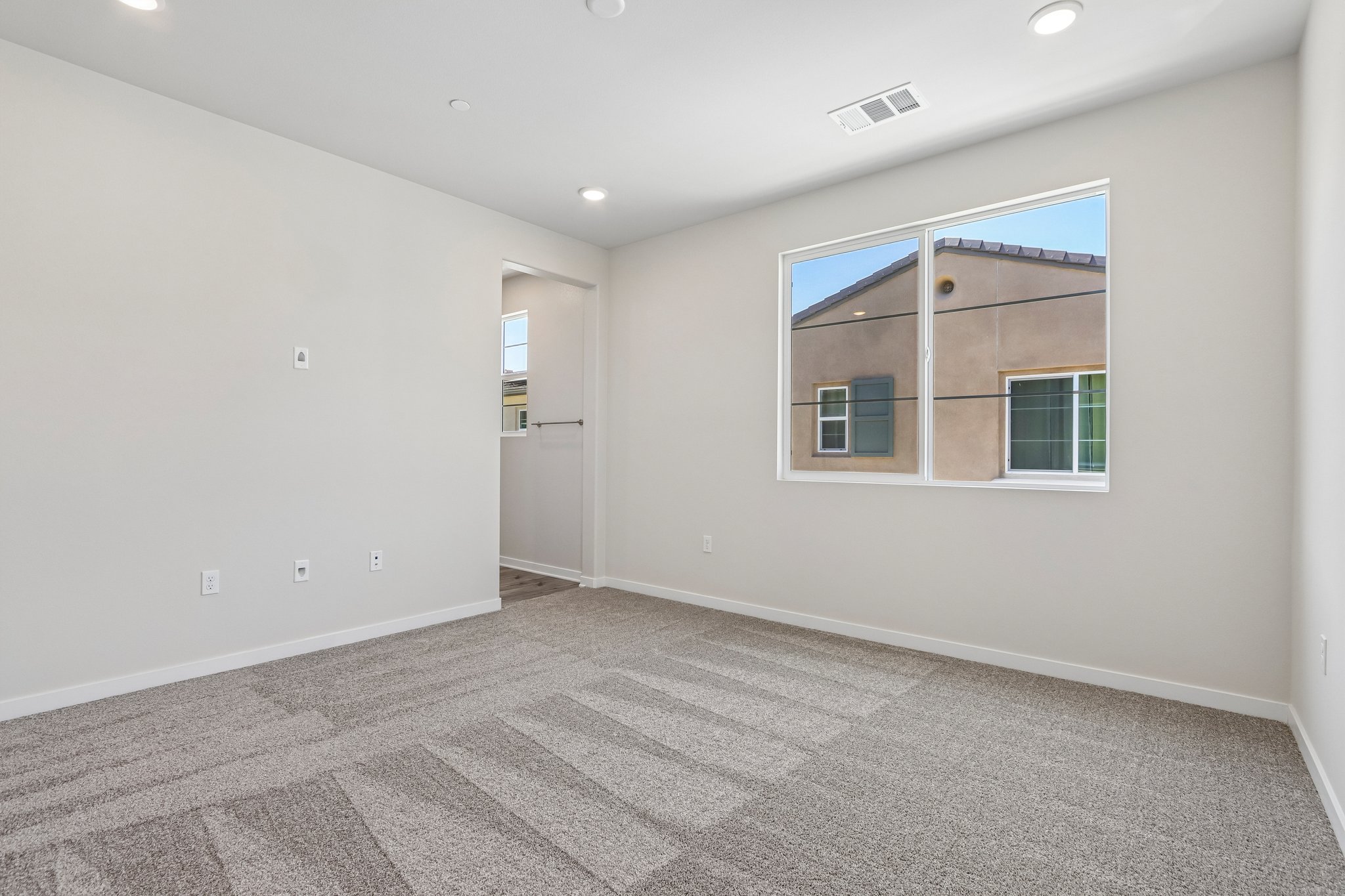 A room with a window and a carpet.