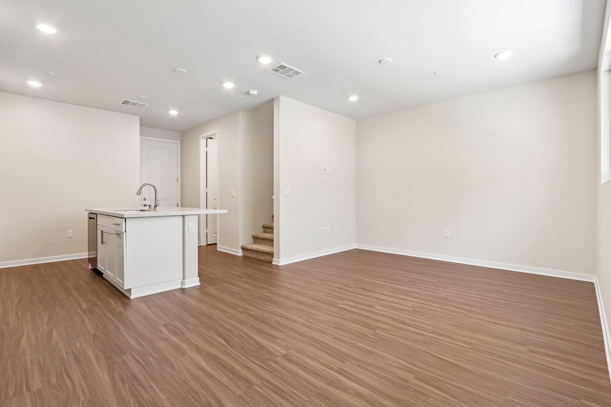A room with white walls and wood floors.