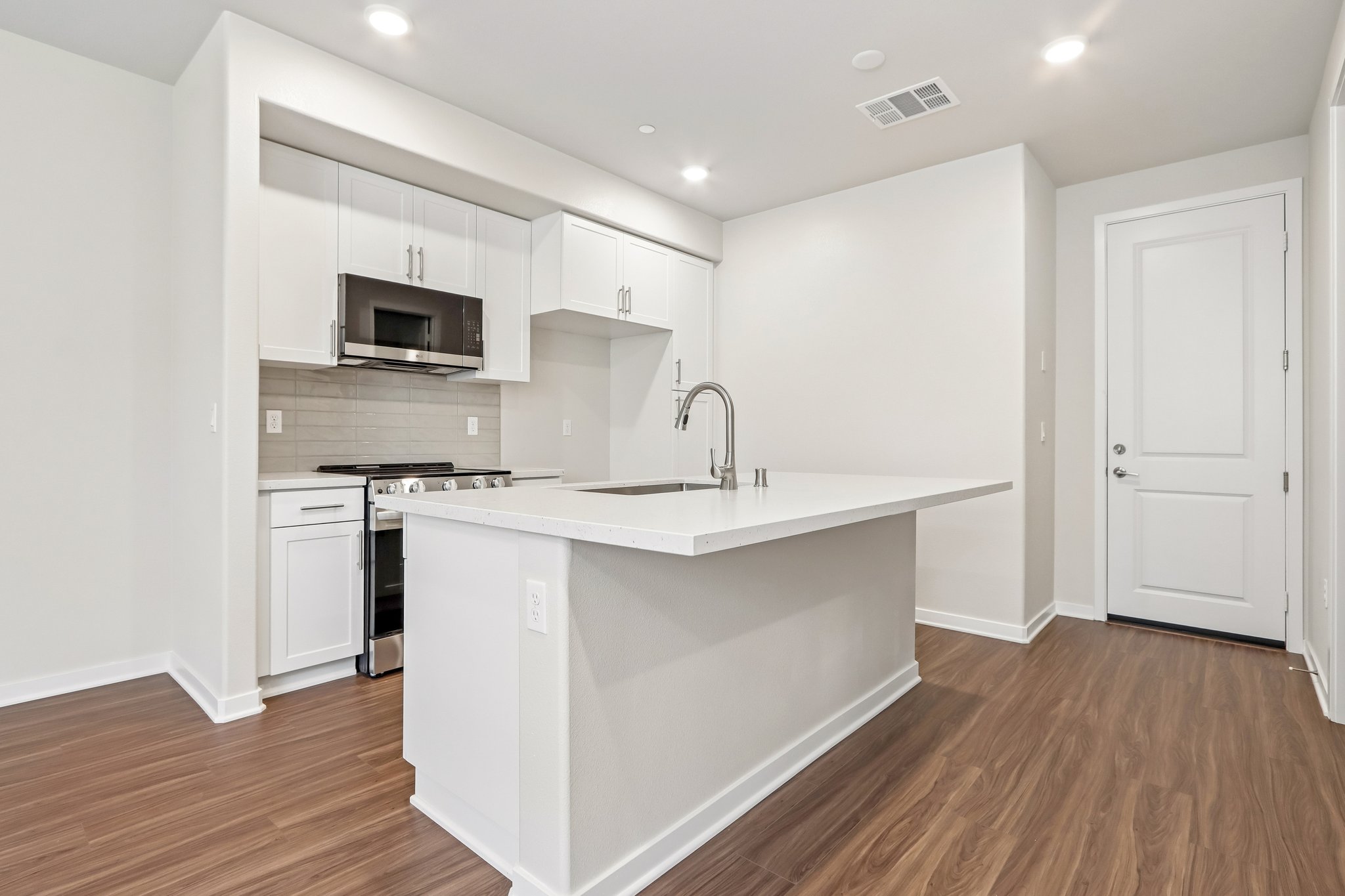 A kitchen with white cabinets.