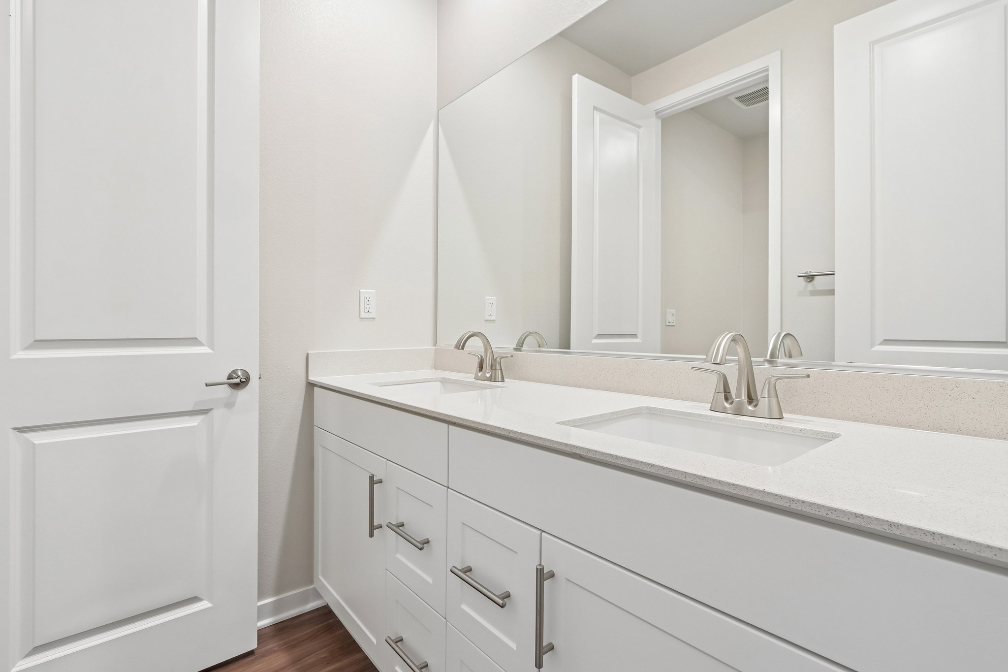 A bathroom with white cabinets.