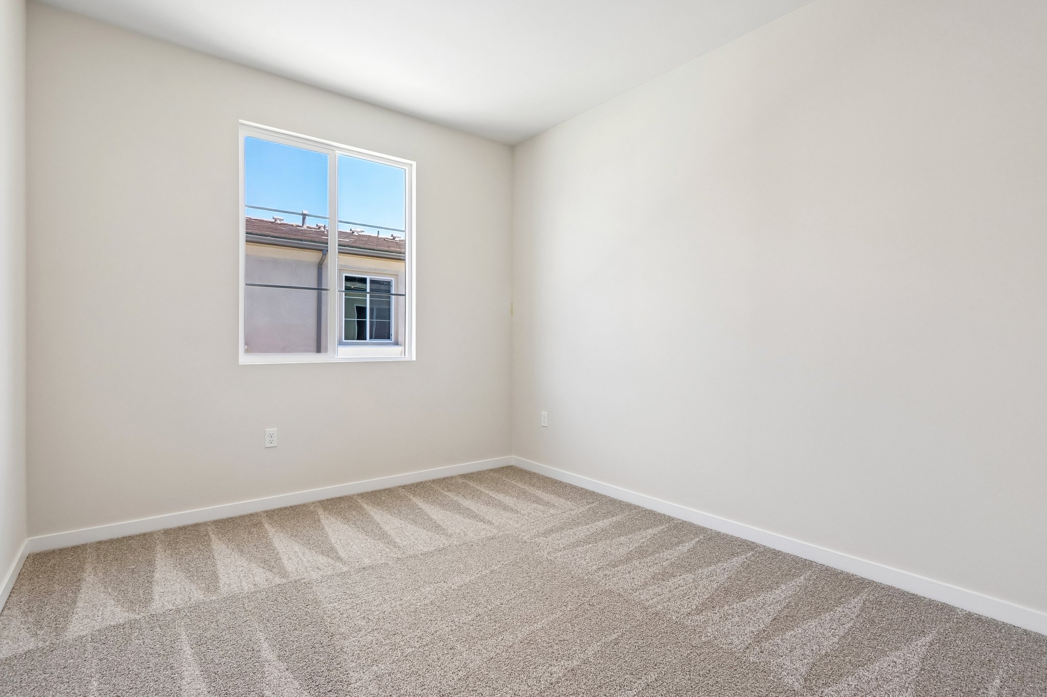 A room with a window and a carpet.