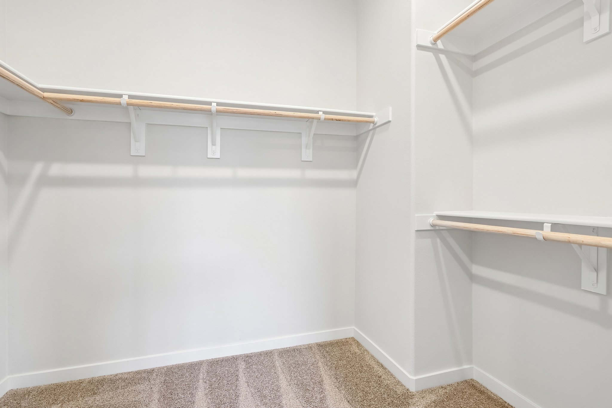 A white wall with a metal bar.