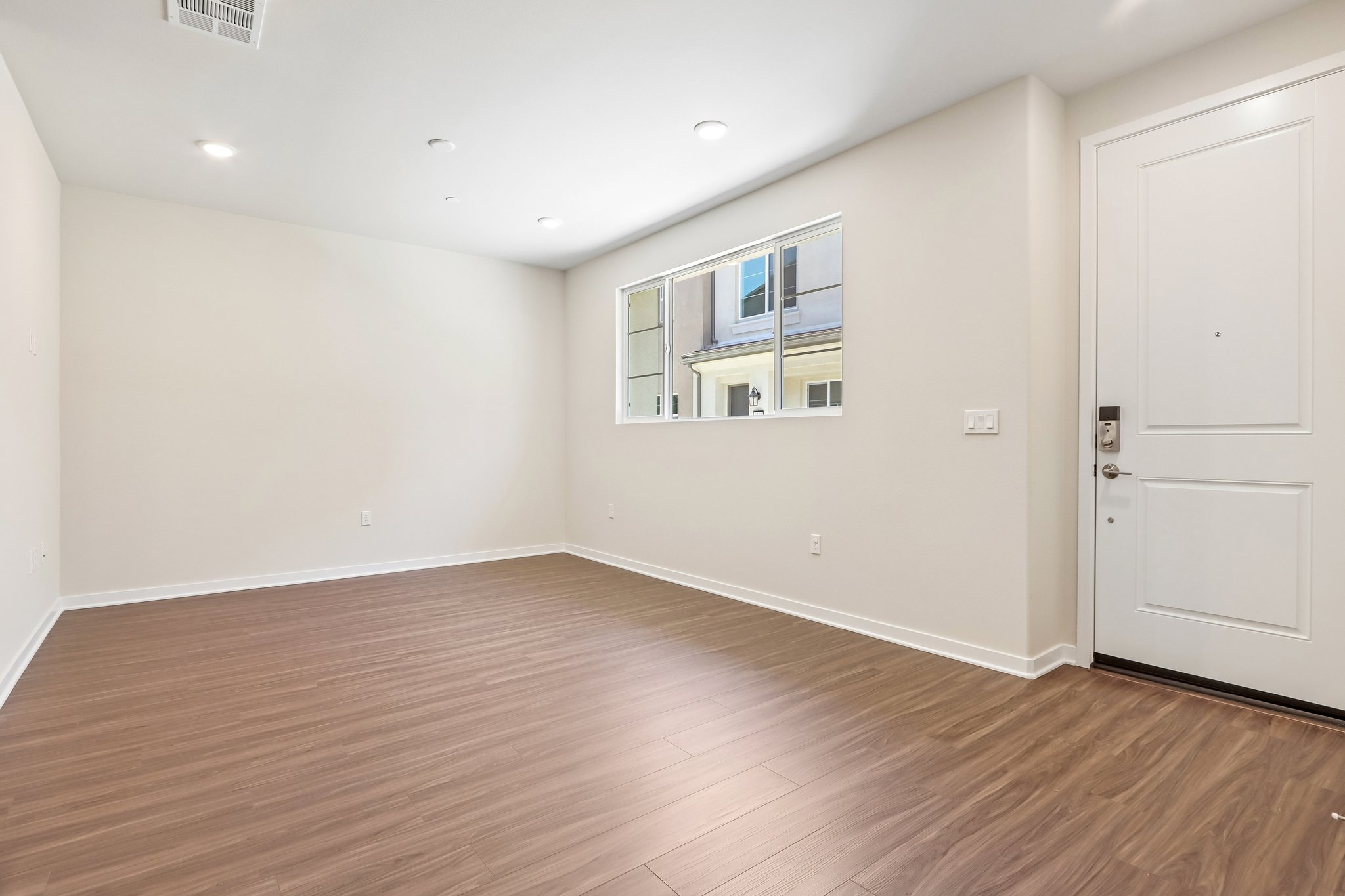 A room with a wood floor and a white door.