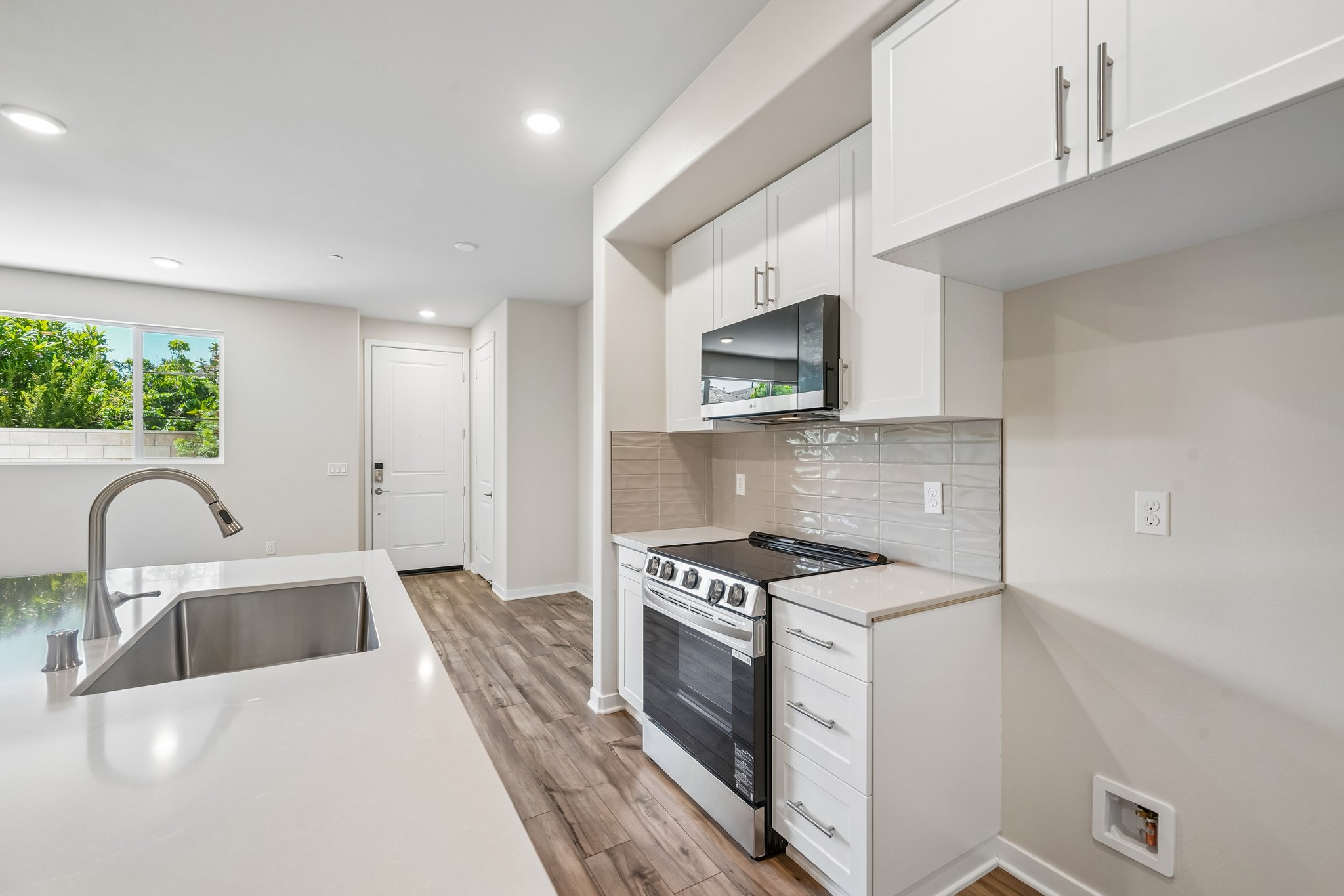 A kitchen with white cabinets.
