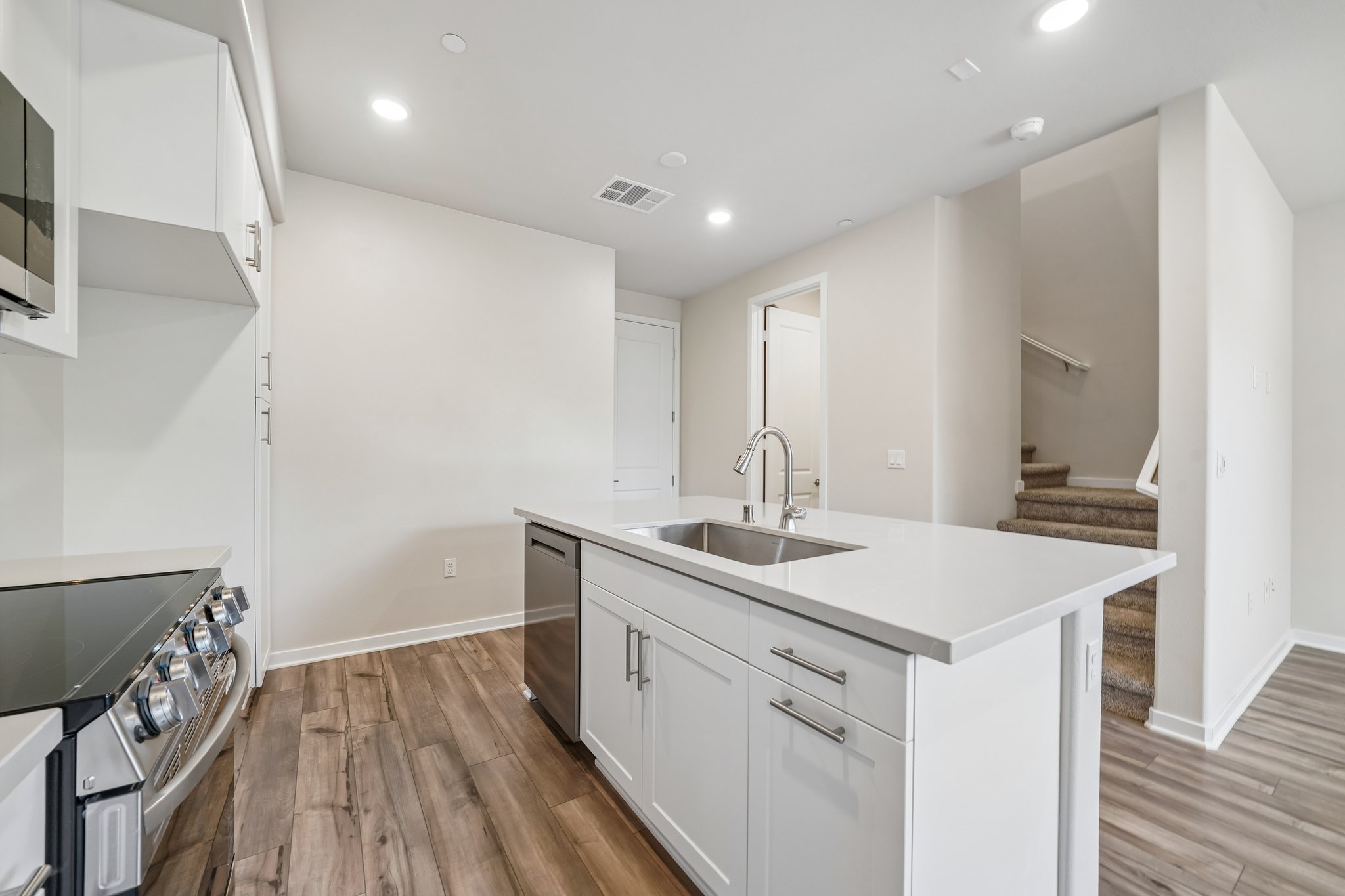 A kitchen with white cabinets.