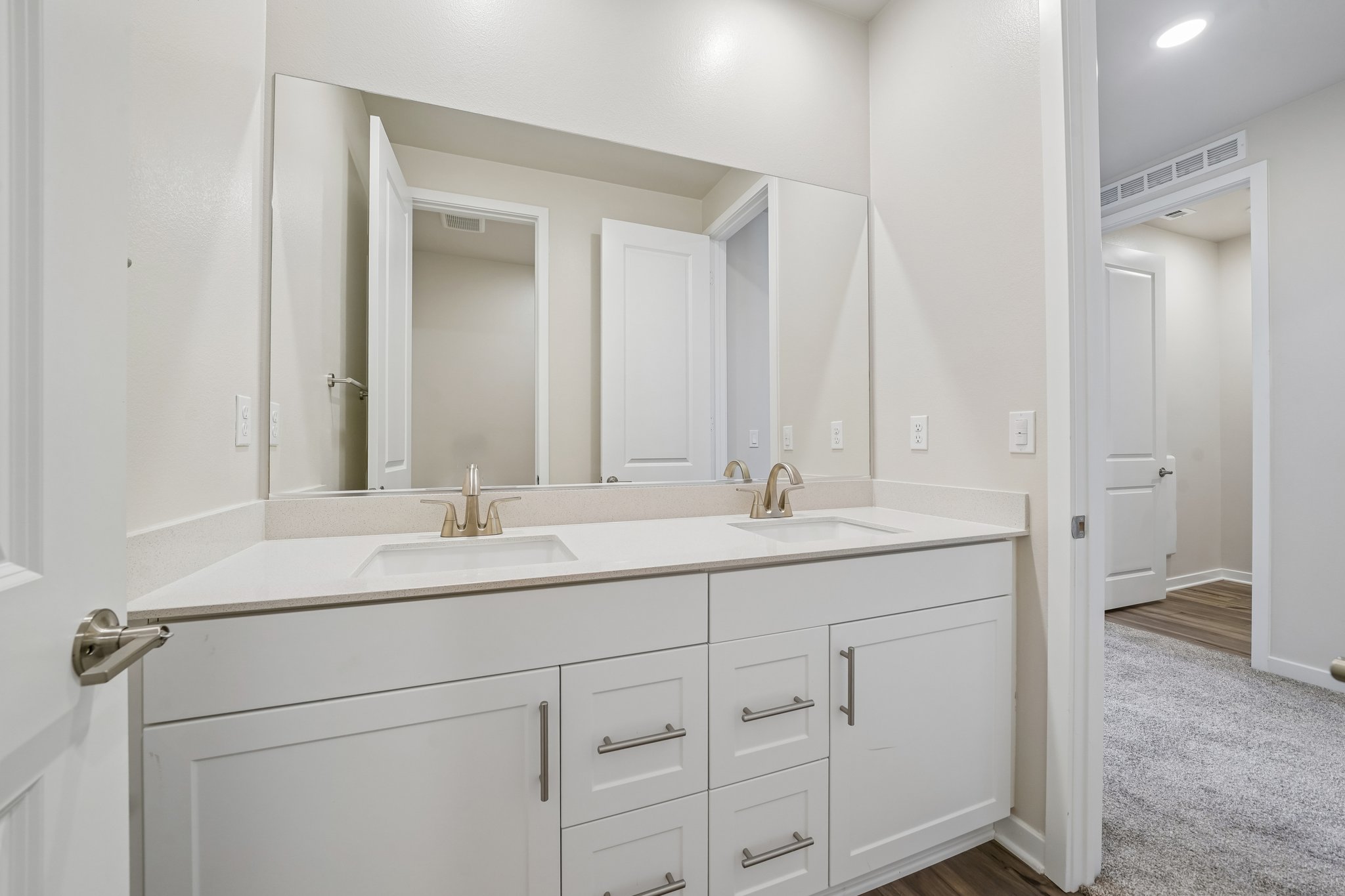A bathroom with white cabinets.