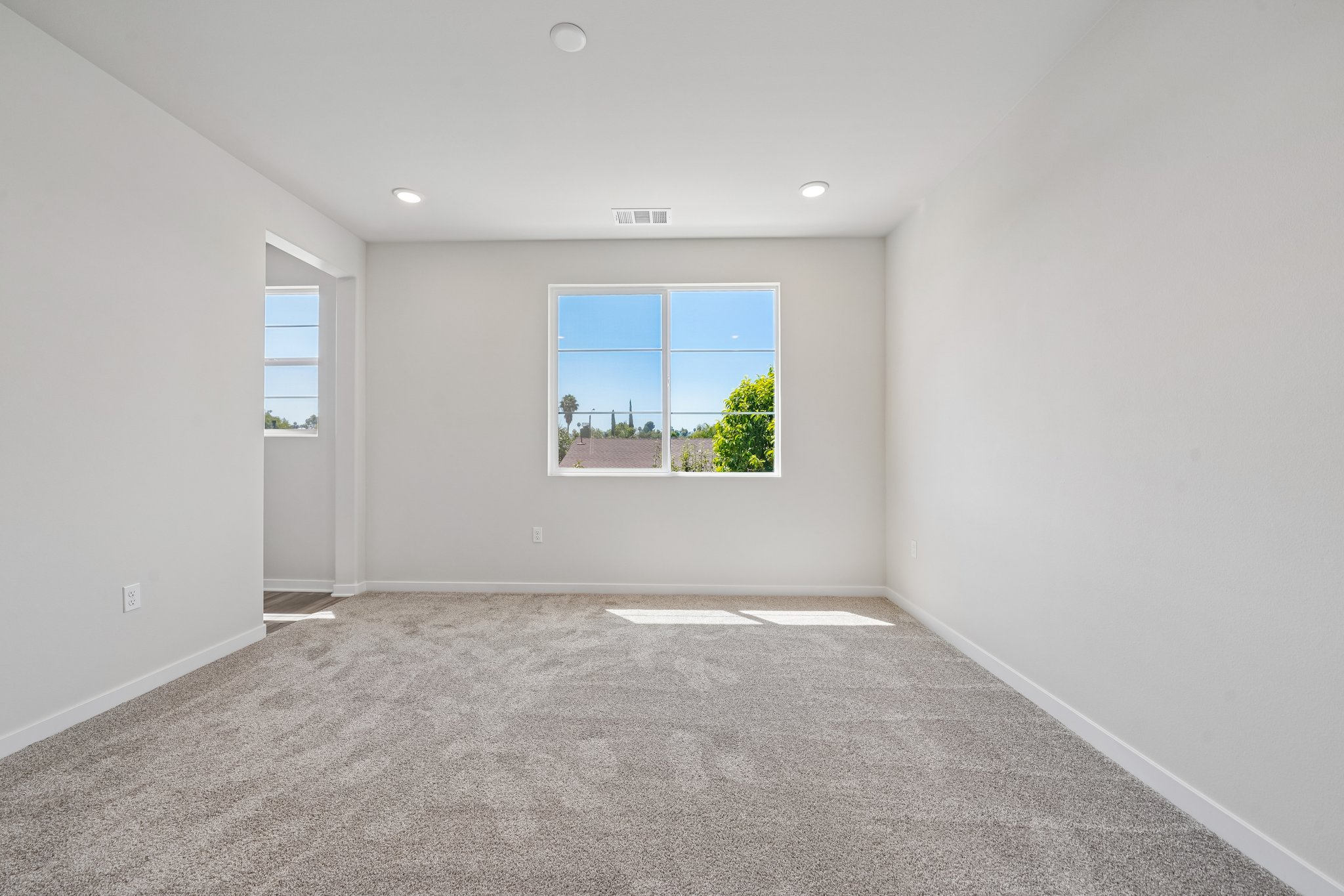 A room with a window and a carpet.