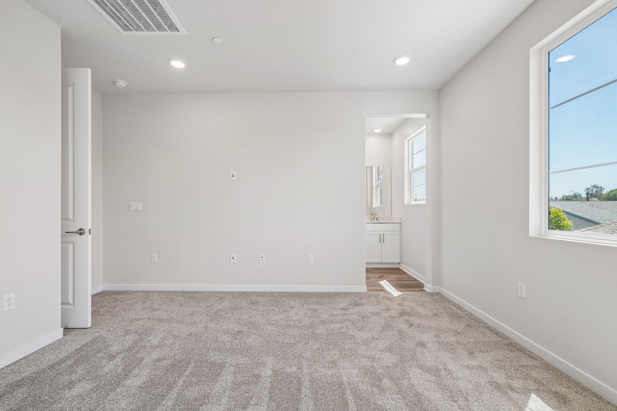 A room with a carpet and a window.