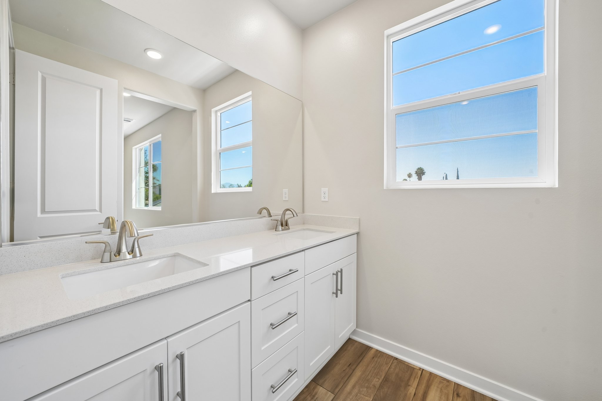 A bathroom with white cabinets.