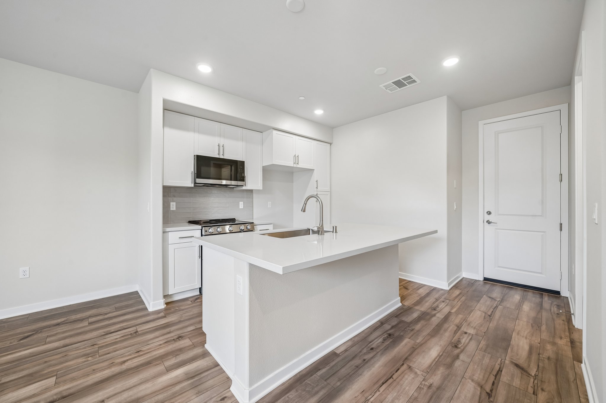 A kitchen with white cabinets.