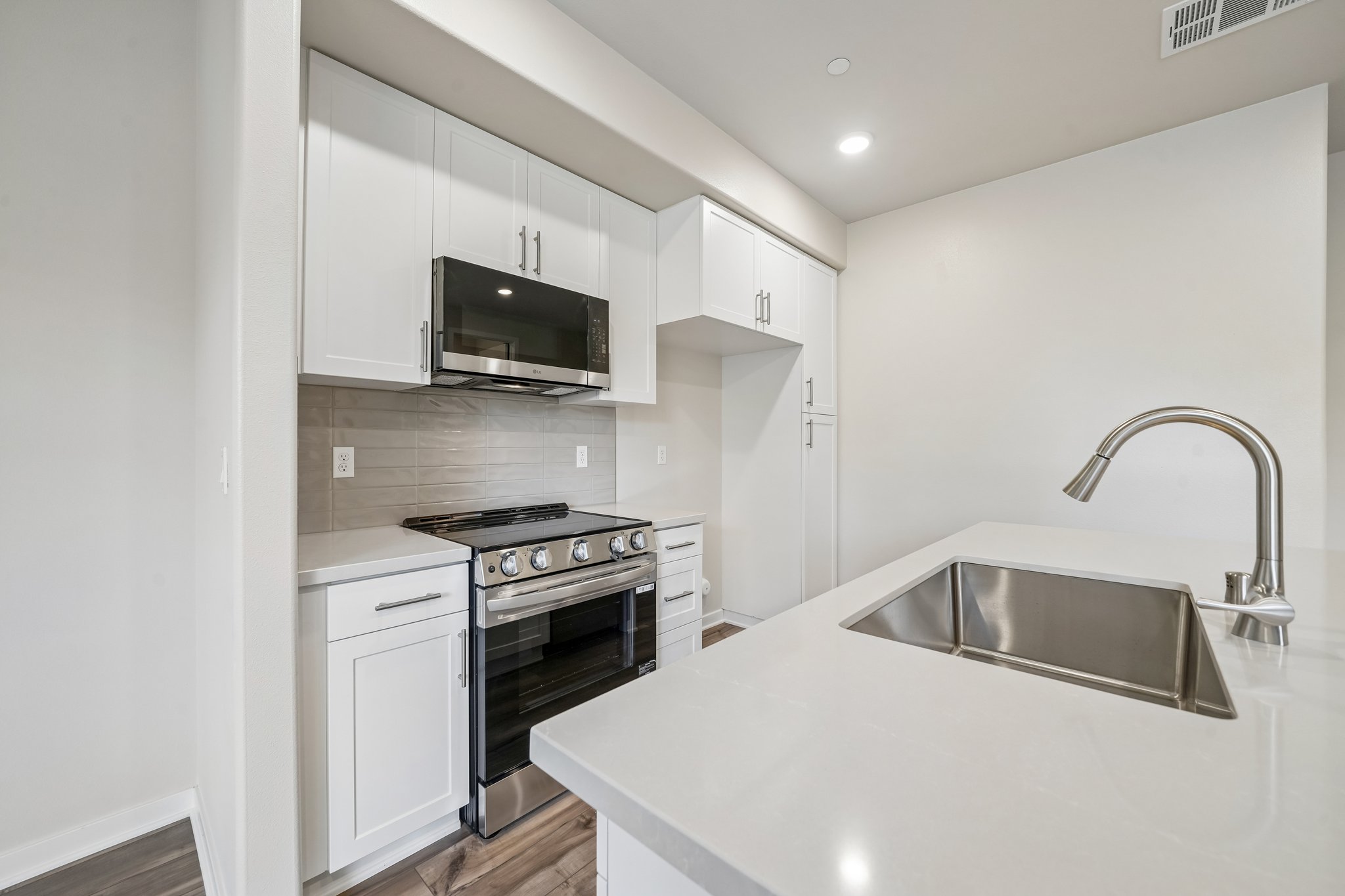 A kitchen with white cabinets.