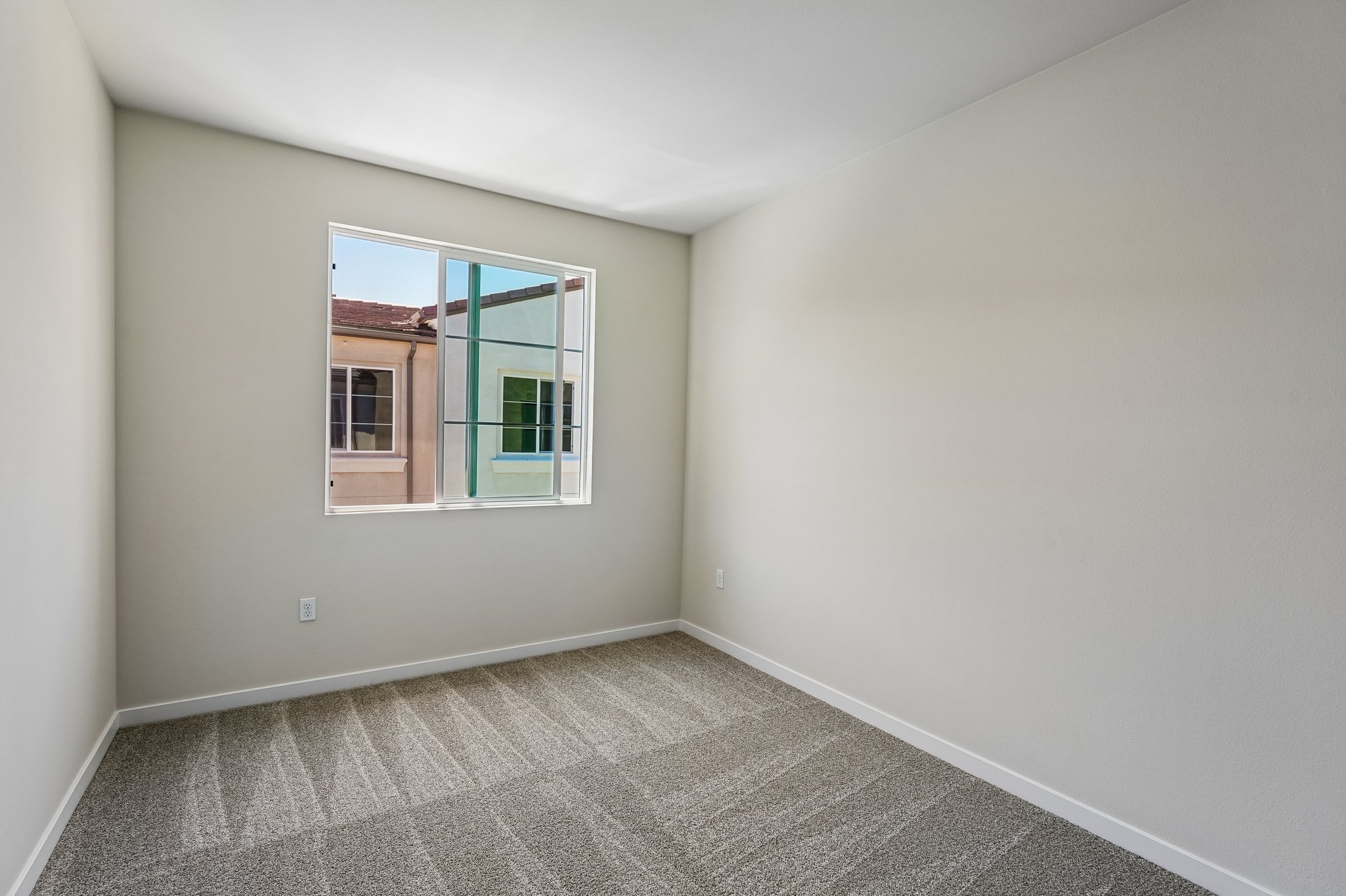 A room with a window and a carpet.