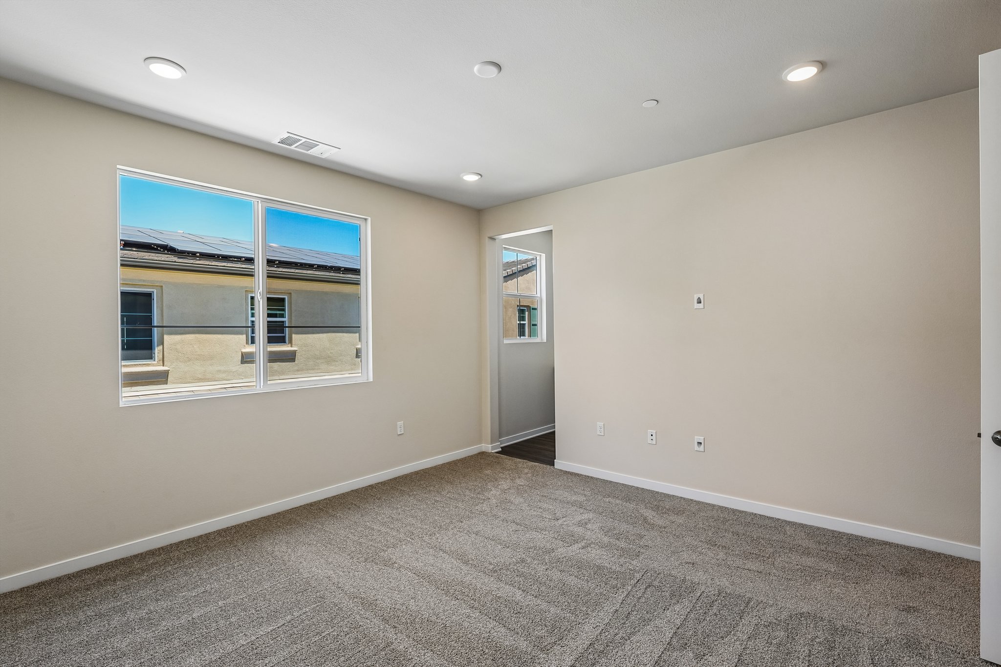 A room with a window and a carpet.