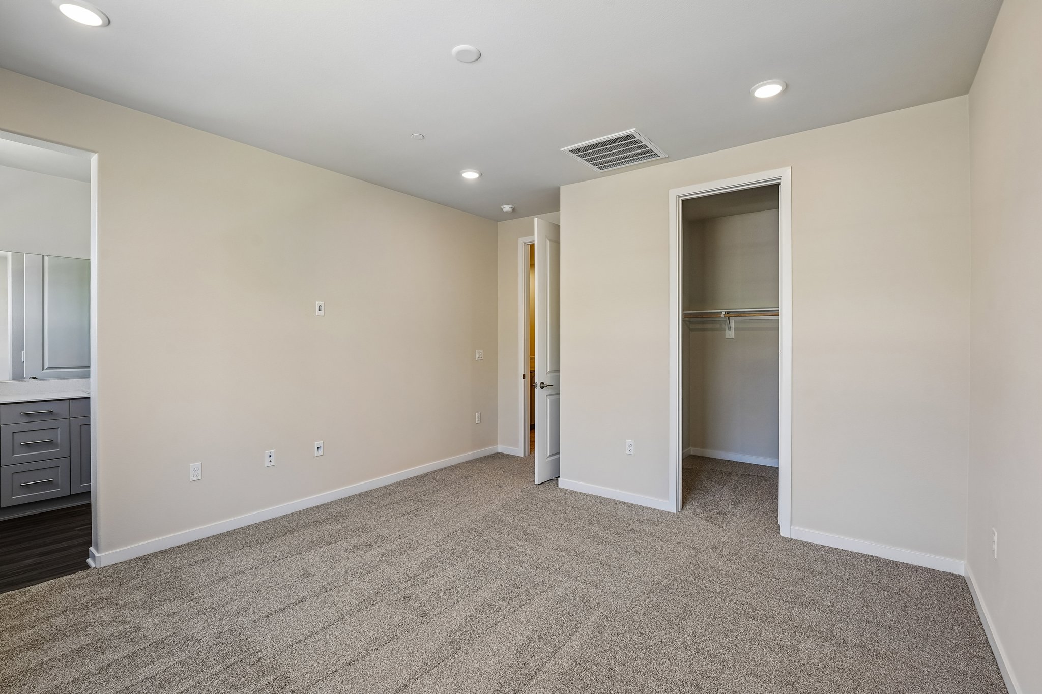 A room with a carpet and a door.