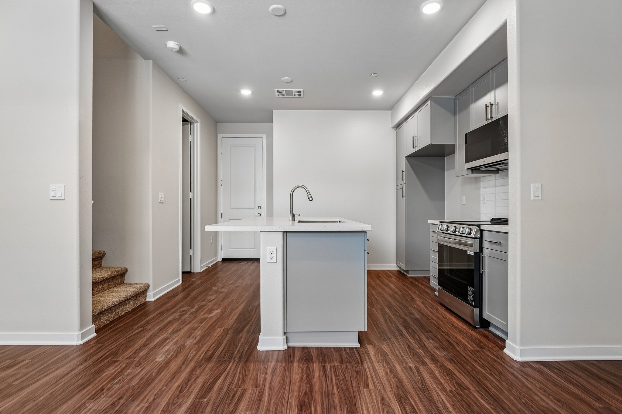A kitchen with white cabinets.