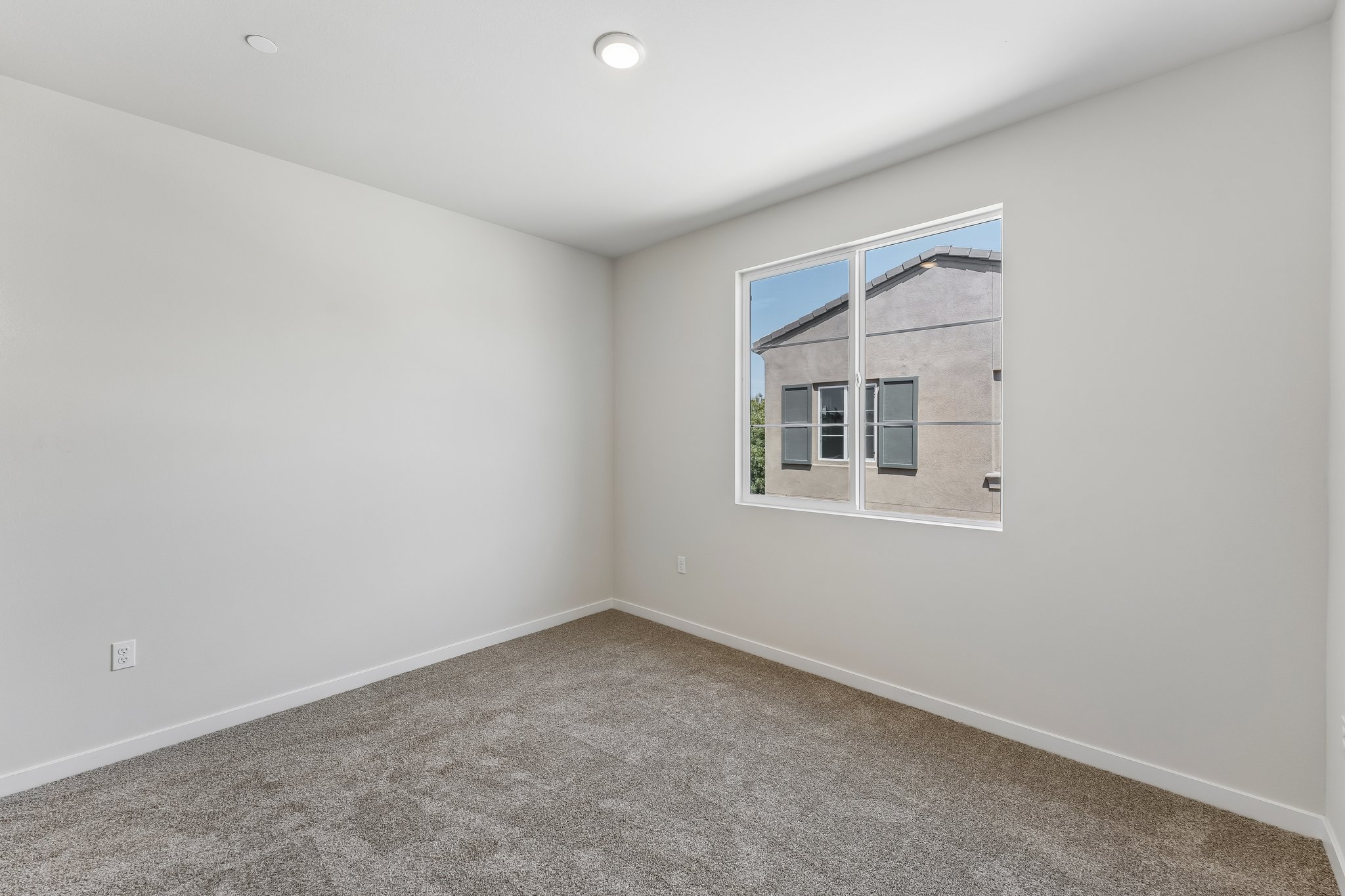 A room with a window and a carpet.